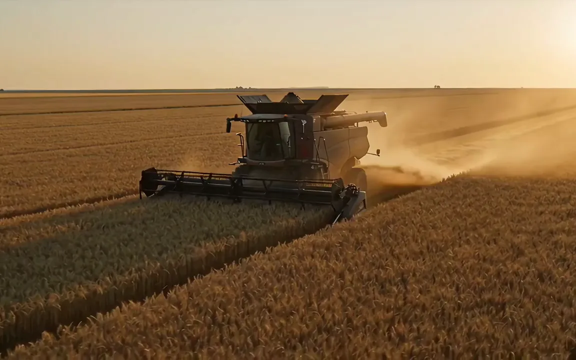 Veo 3.1 video of a combine harvester crossing a golden field at dusk