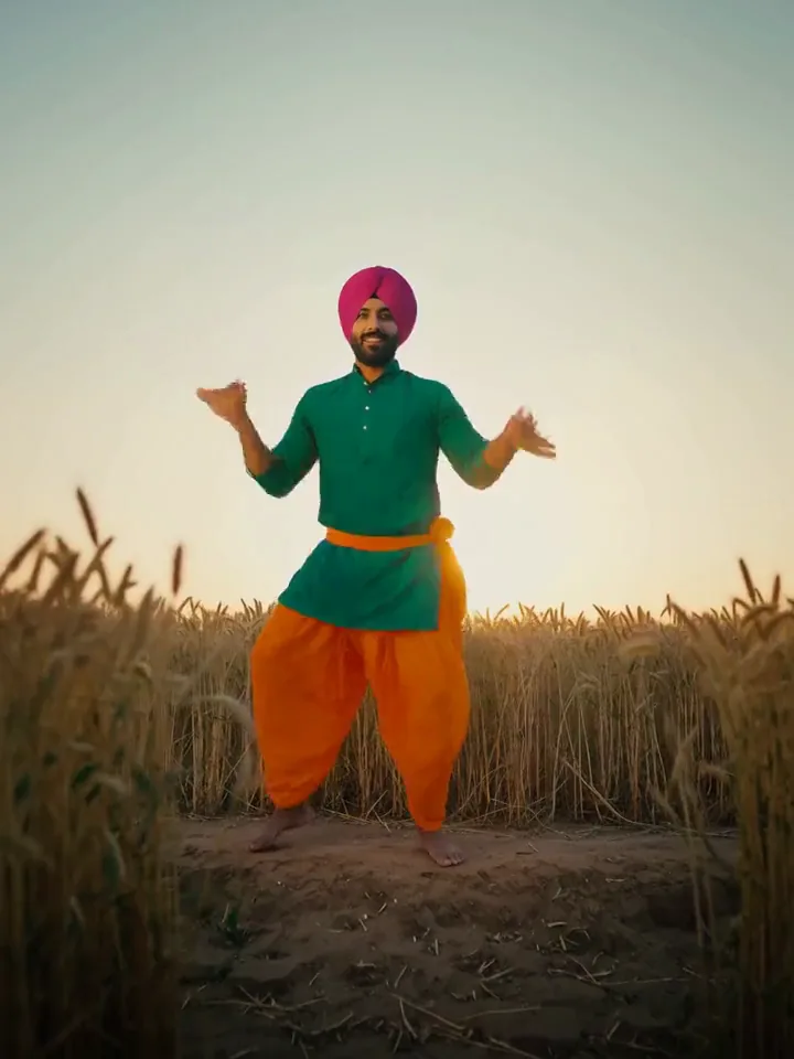 Gemini Omni video of a Bhangra dancer in a magenta turban raising his arms and one knee in a golden wheat field