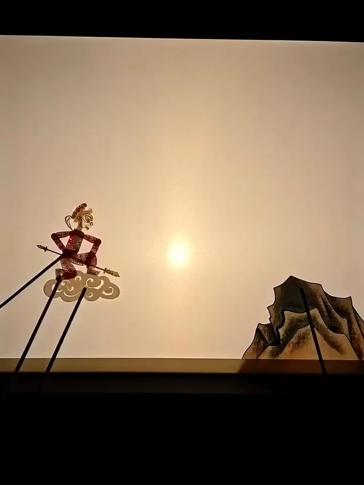 Kling 3.0 video of a shadow puppet on rods leaping onto a mountain peak on a lit screen