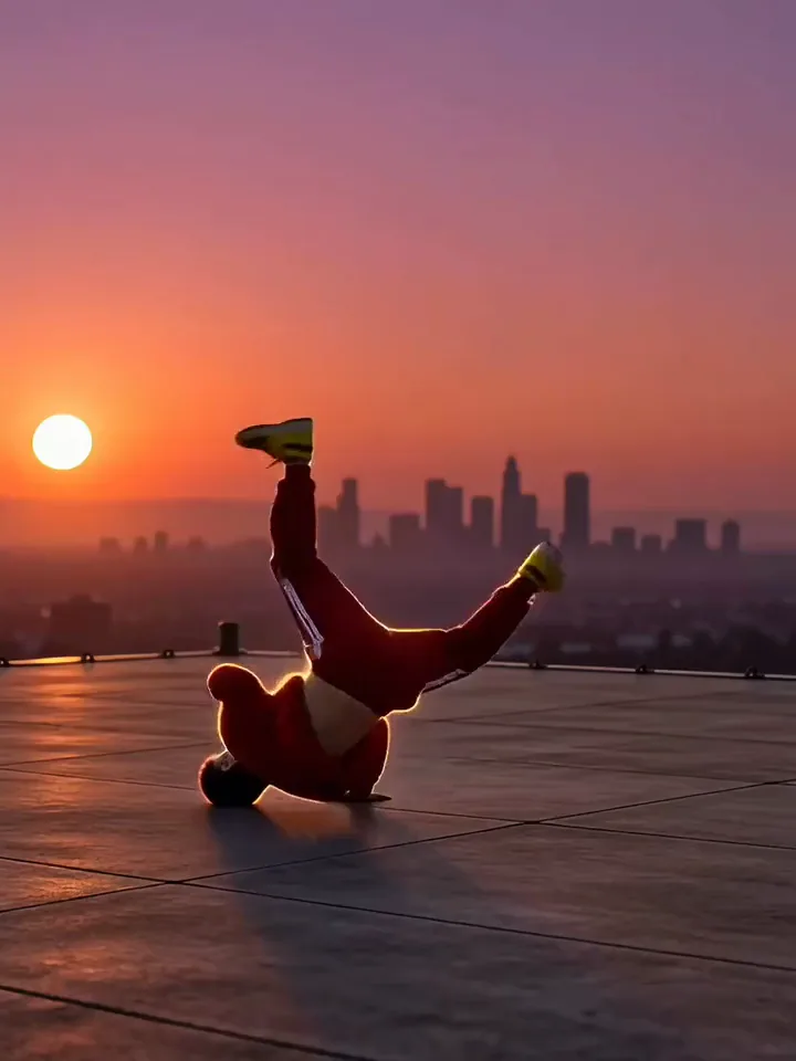 Video Kling AI về vũ công breakdance áo đỏ xoay người trên sân thượng lúc hoàng hôn