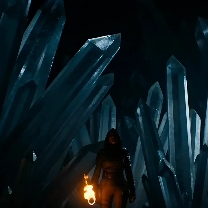Hooded ranger raising a torch in a cave as giant blue crystals glow