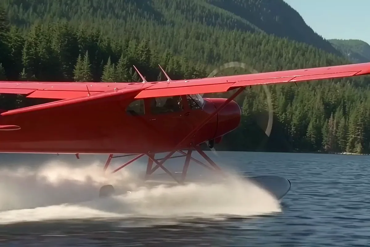 AI video generator clip of a red seaplane lifting off a mountain lake in a spray of water