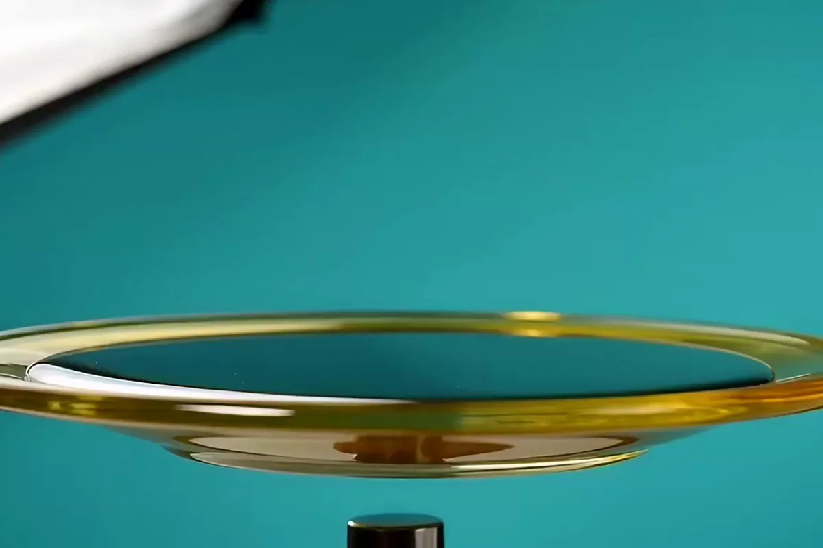 Gemini Omni video of black ferrofluid on a yellow dish pulling into a crown of sharp spikes as a magnet slides underneath