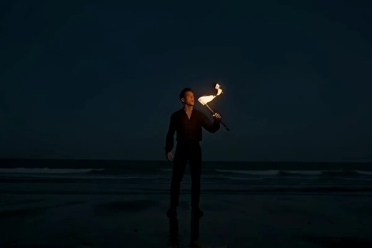 MiniMax H3 video of a fire breather on a night beach blowing a big plume of orange flame