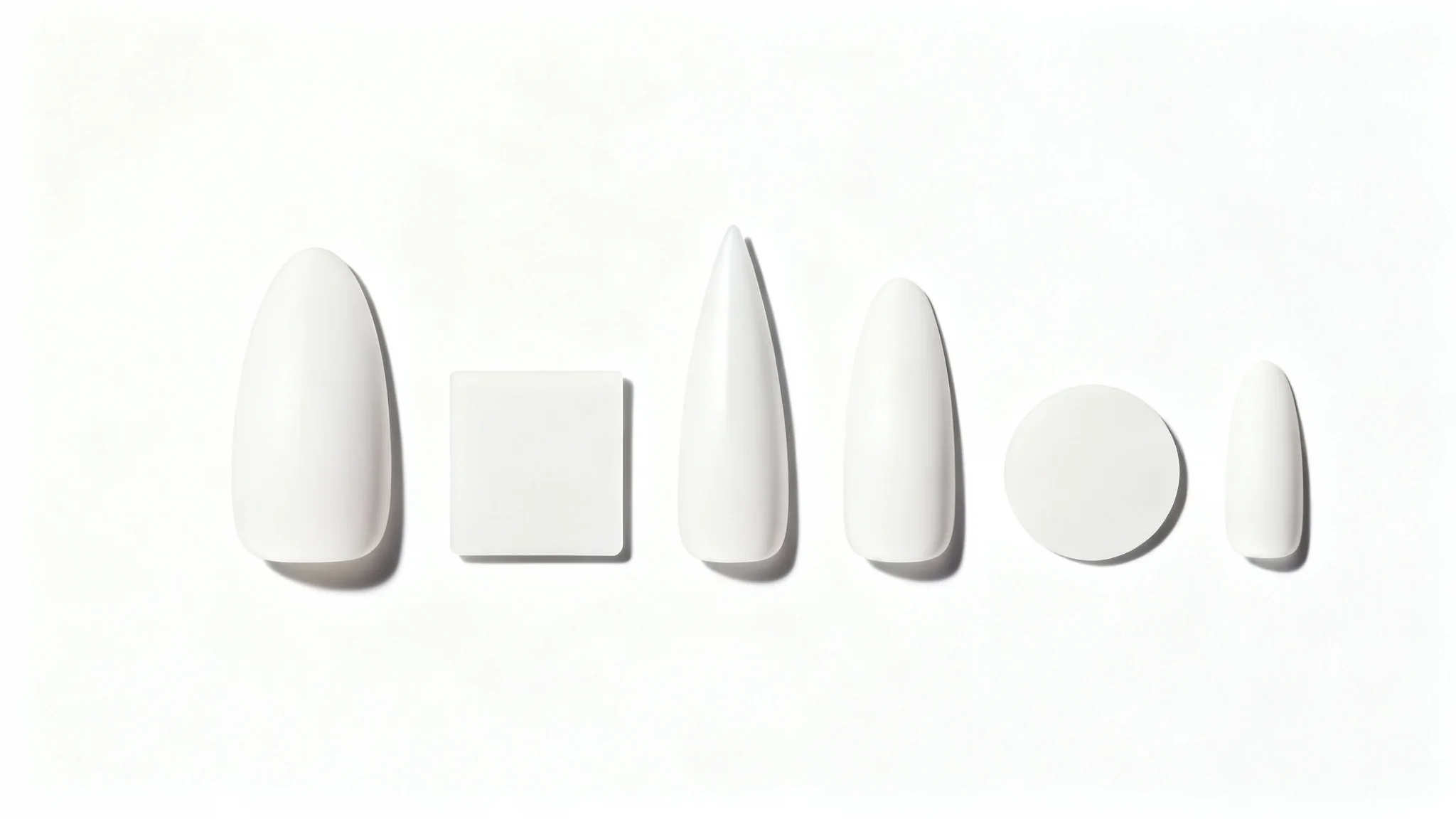 An organized row of artificial nail tips in various shapes, almond, square, coffin, stiletto, round, and oval, on a white background.