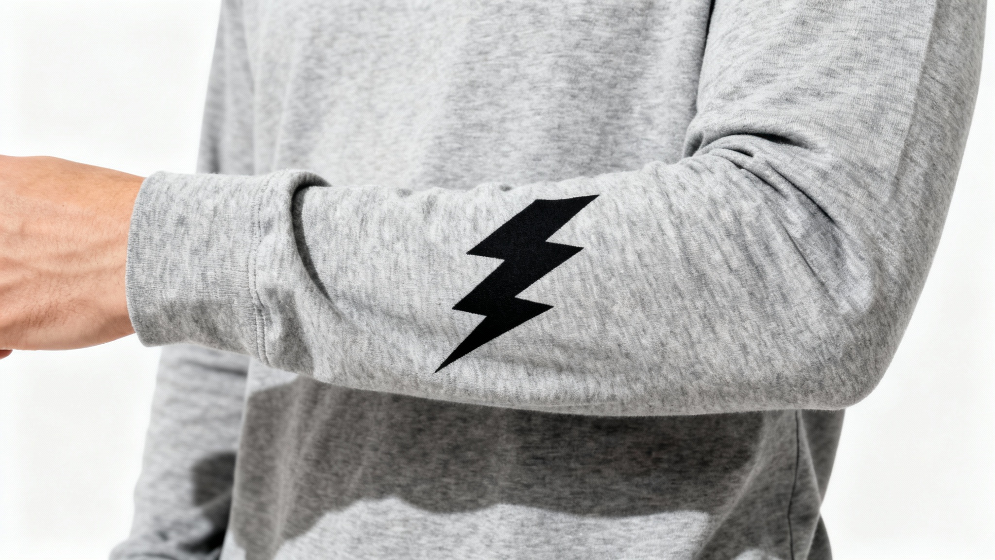 A close-up mockup of a heather grey long-sleeve shirt, showing a black lightning bolt graphic perfectly printed on the forearm. The background is solid white.