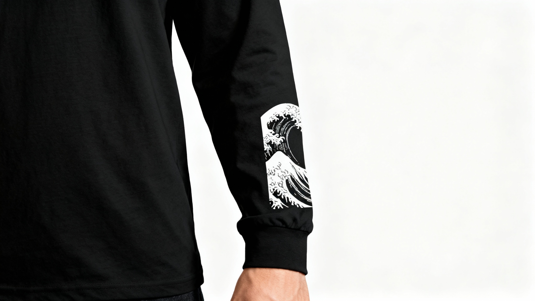 A close-up product mockup of a black long-sleeve shirt, highlighting a crisp white Japanese wave graphic printed on the sleeve against a white background.