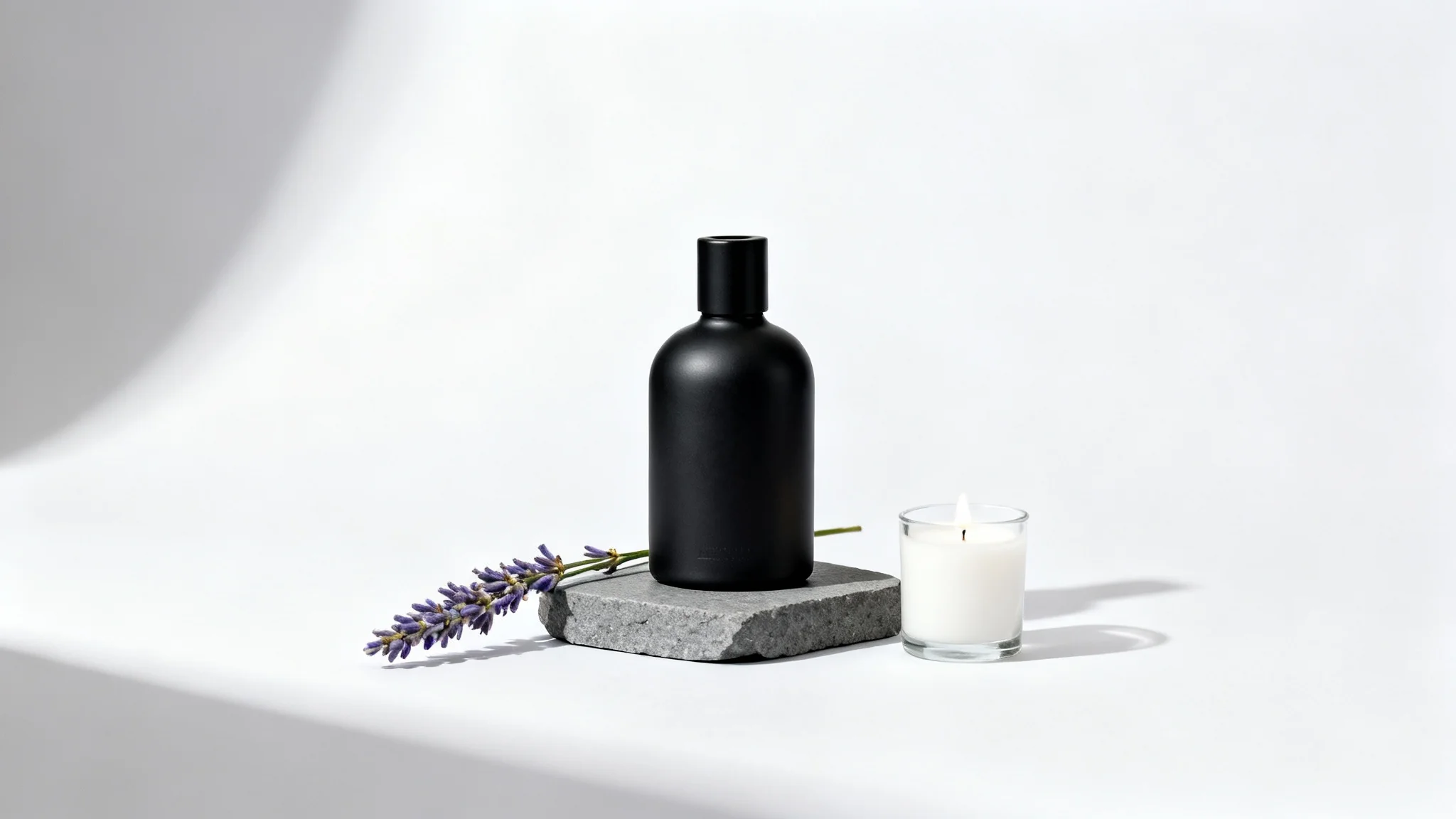 A minimalist product scene featuring a matte black cologne bottle on a grey slate block, next to a sprig of lavender and a small candle, all on a clean white background.