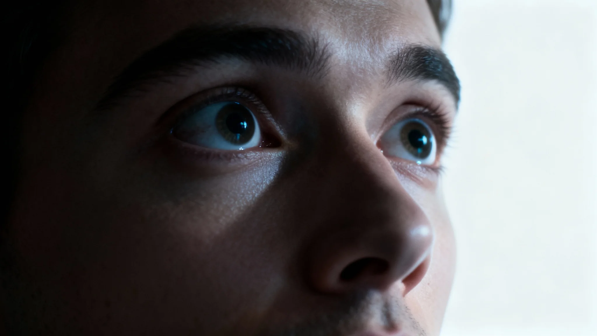 A dramatic close-up photo of a person's face showing an expression of surprise and intrigue, symbolizing the captivating effect of a strong video hook.