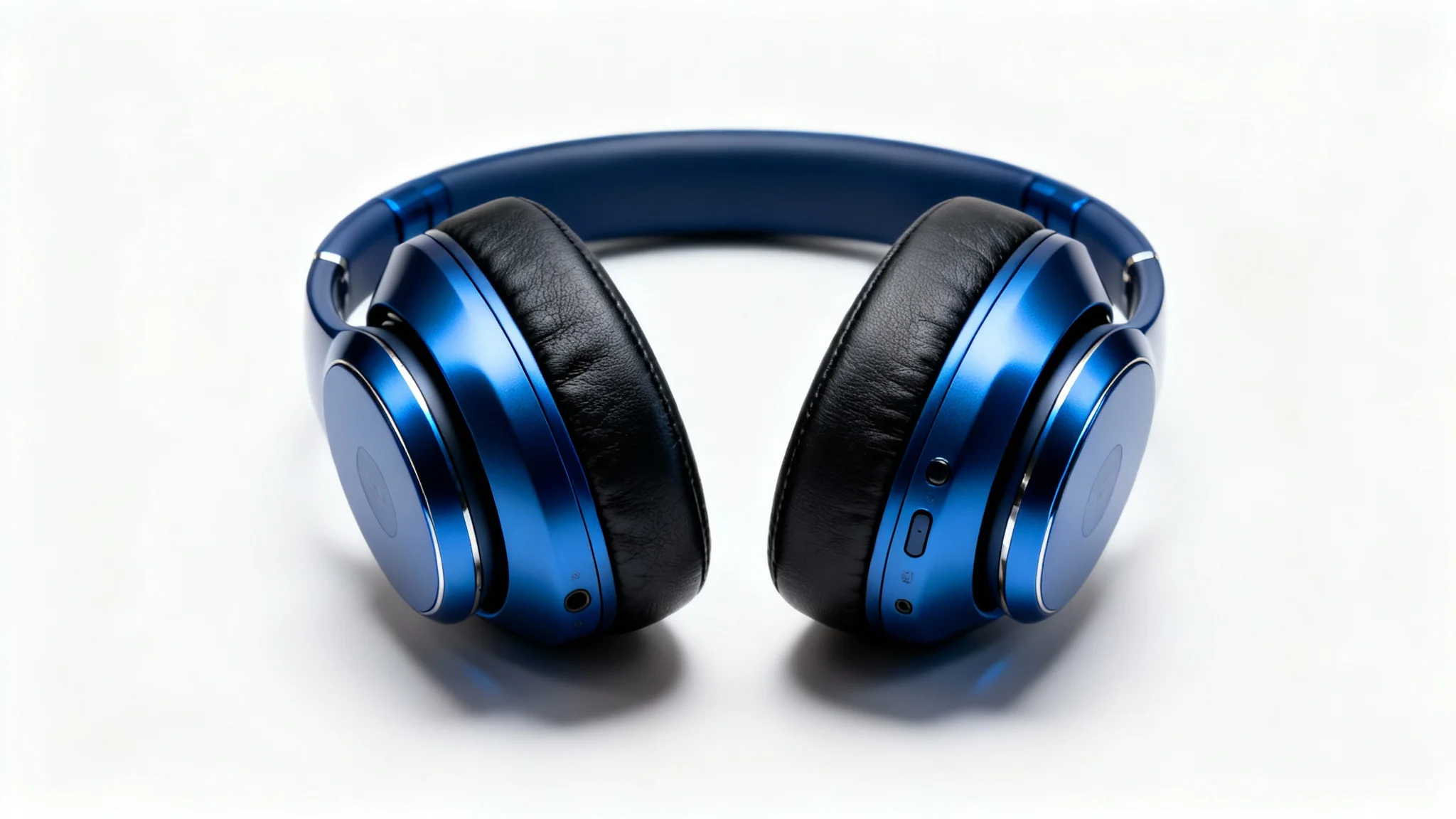 A professional product photograph of a pair of sleek, metallic blue wireless headphones resting on a clean white background, illuminated by soft studio lights.
