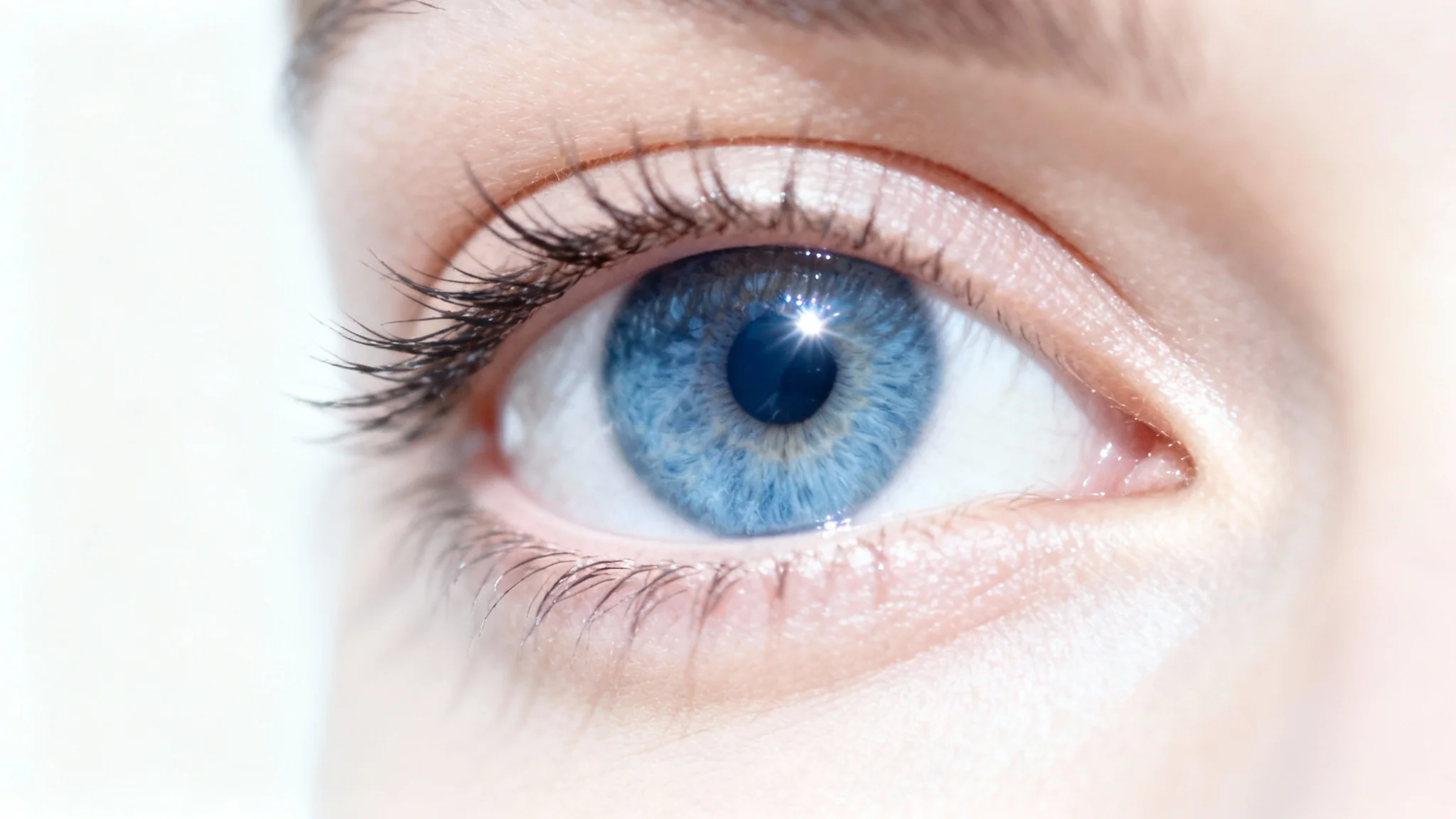 A close-up photorealistic mockup of a woman's bright blue eye, wide open and alert, against a stark white background, symbolizing an 'eye-opening' effect.