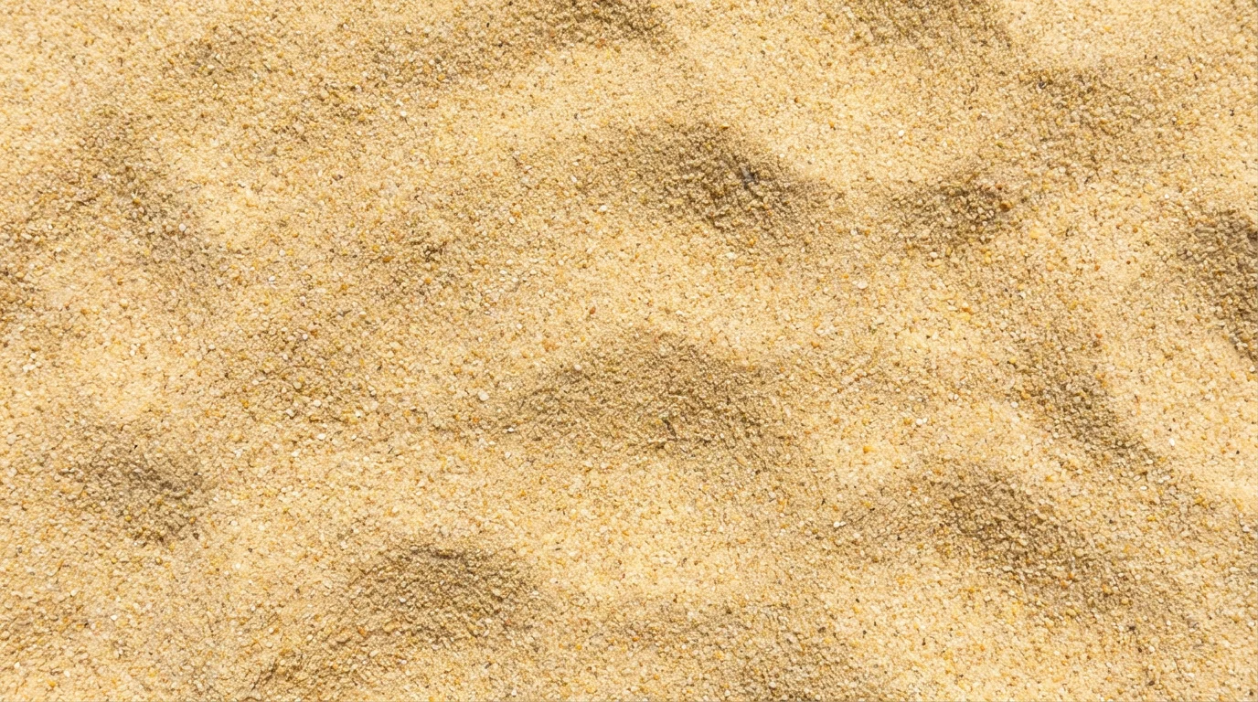A seamless, tileable macro photograph of fine golden sand, showing detailed grains and gentle ripples under bright sunlight.