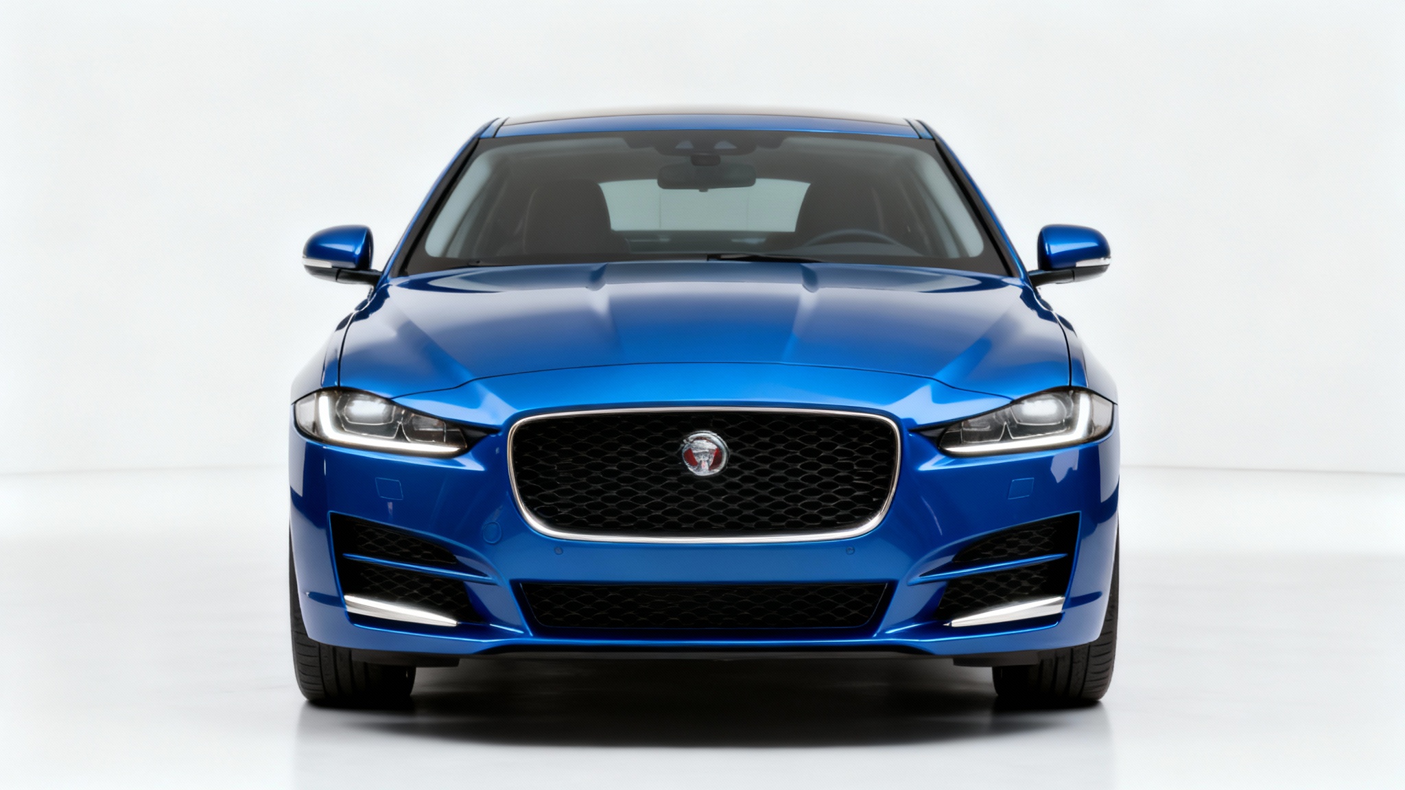 Front view of a modern blue car on a white background, with the license plate digitally removed to show a clean, smooth bumper.