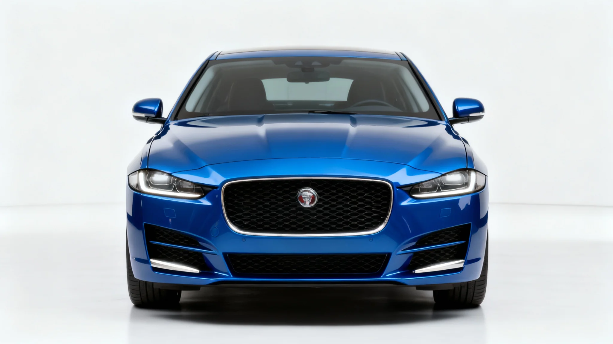 Front view of a modern blue car on a white background, with the license plate digitally removed to show a clean, smooth bumper.