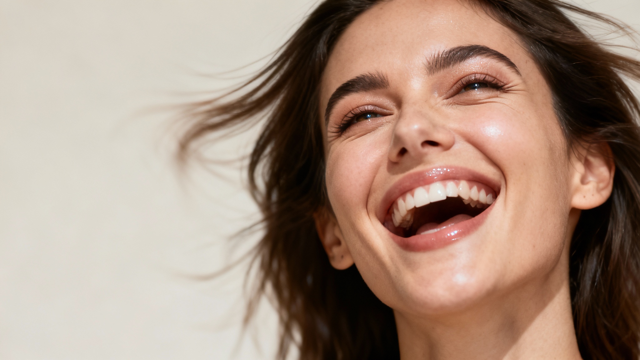 A hyper-realistic image of a woman's face animated to be in the middle of a joyful laugh, with motion blur effects indicating movement and life.