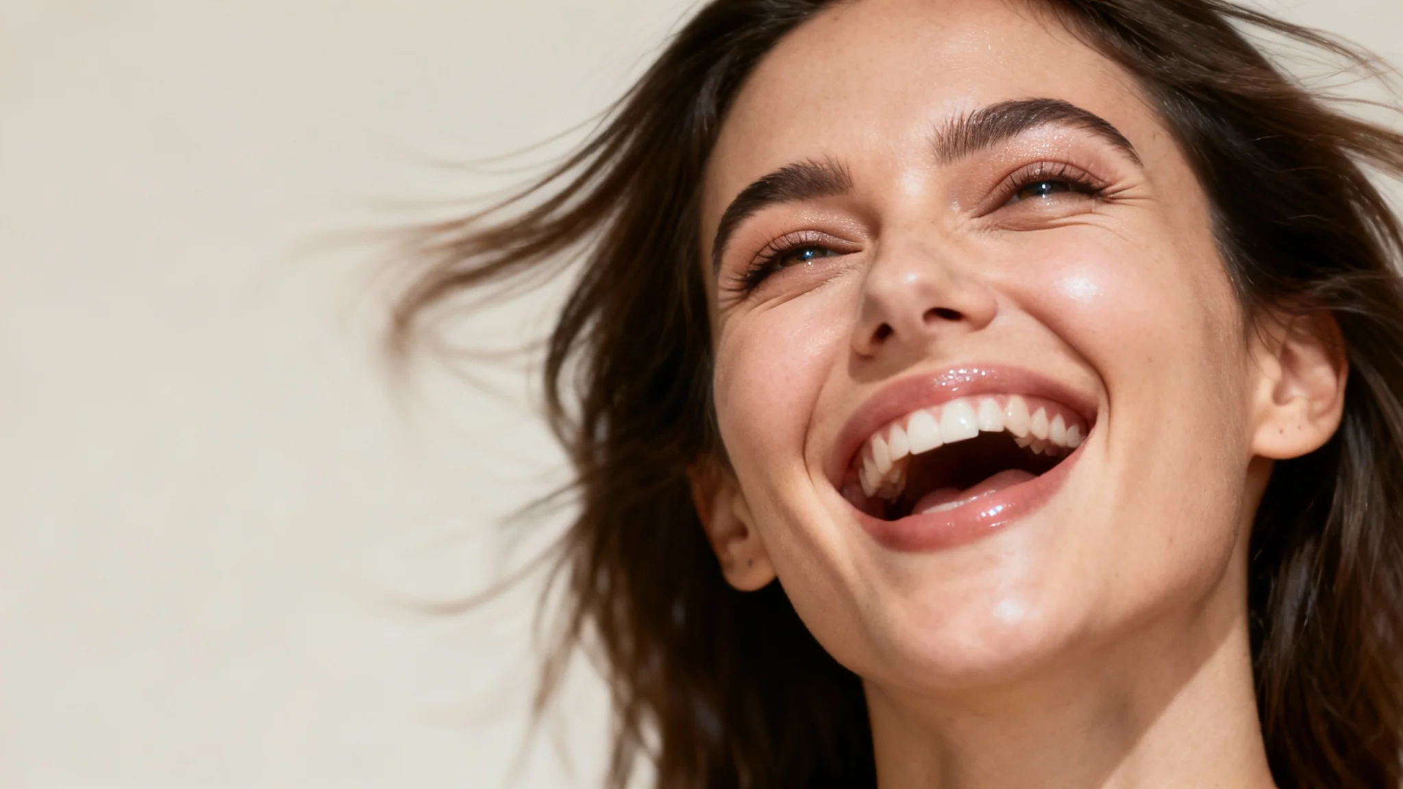 A hyper-realistic image of a woman's face animated to be in the middle of a joyful laugh, with motion blur effects indicating movement and life.