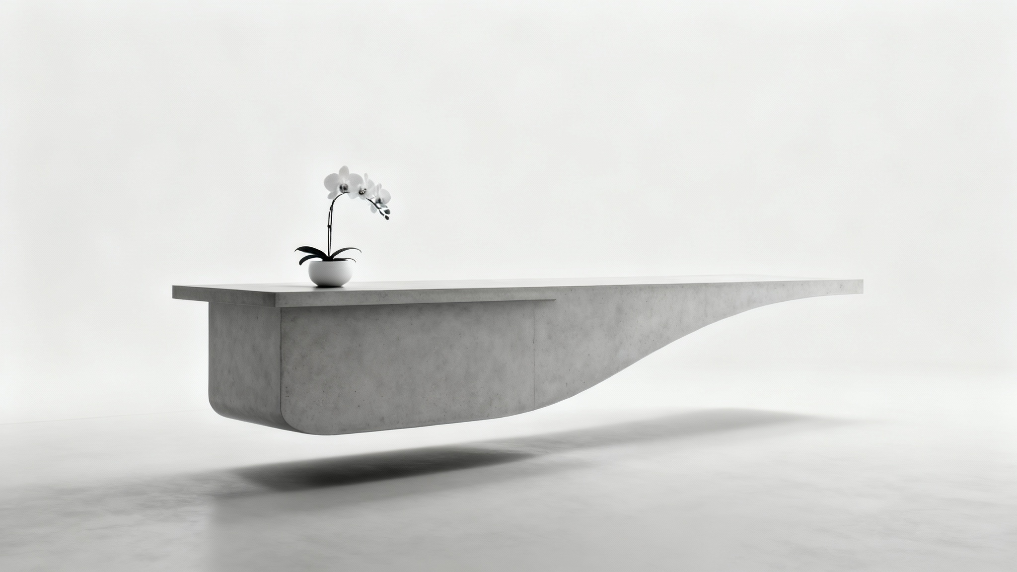 A minimalist reception desk made of curved, light gray concrete, with a single orchid plant on top, set against a plain white background.