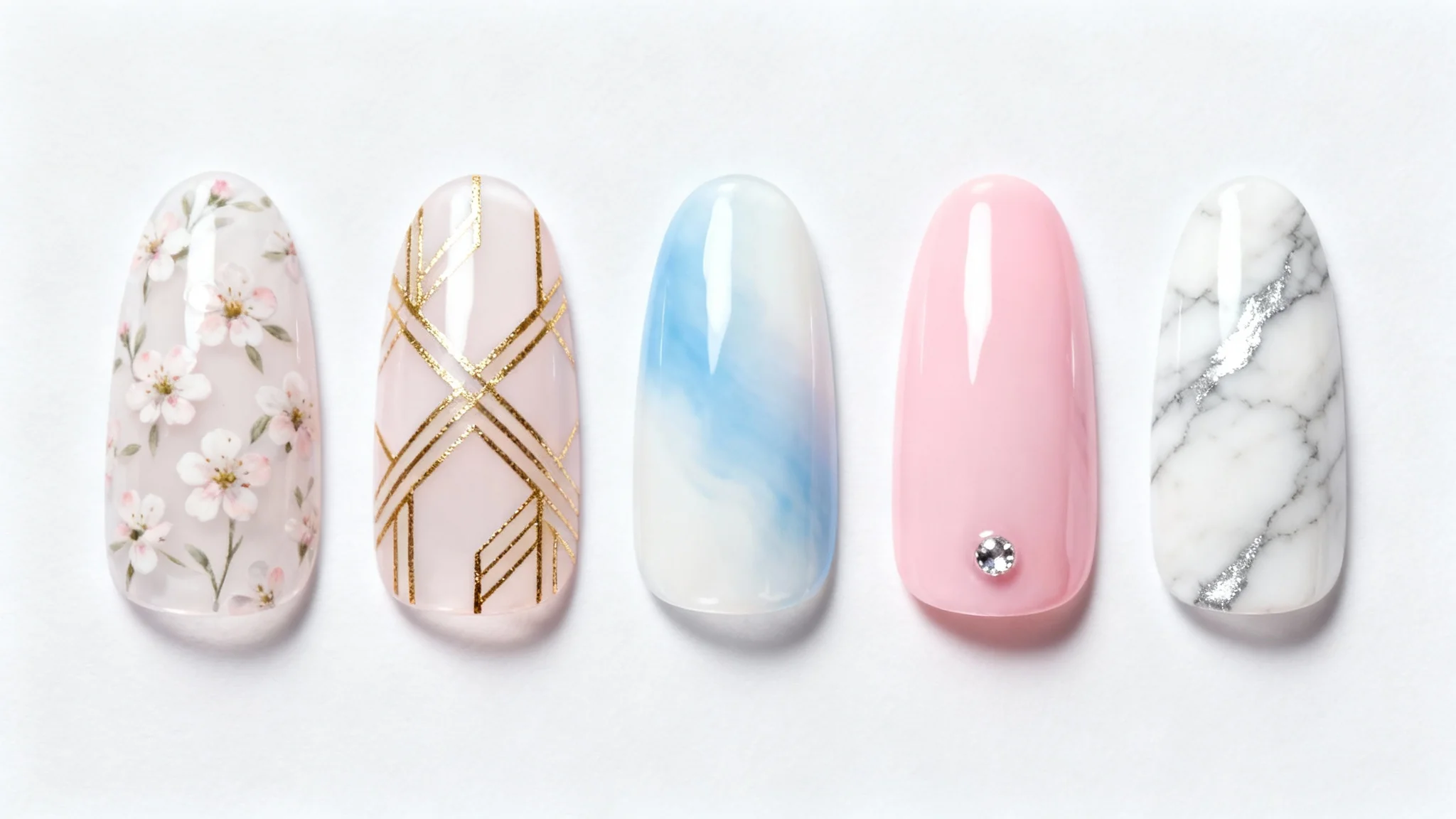 A collection of five sample nail tips with different, intricate designs including floral, geometric, and ombre patterns, displayed against a clean white background.