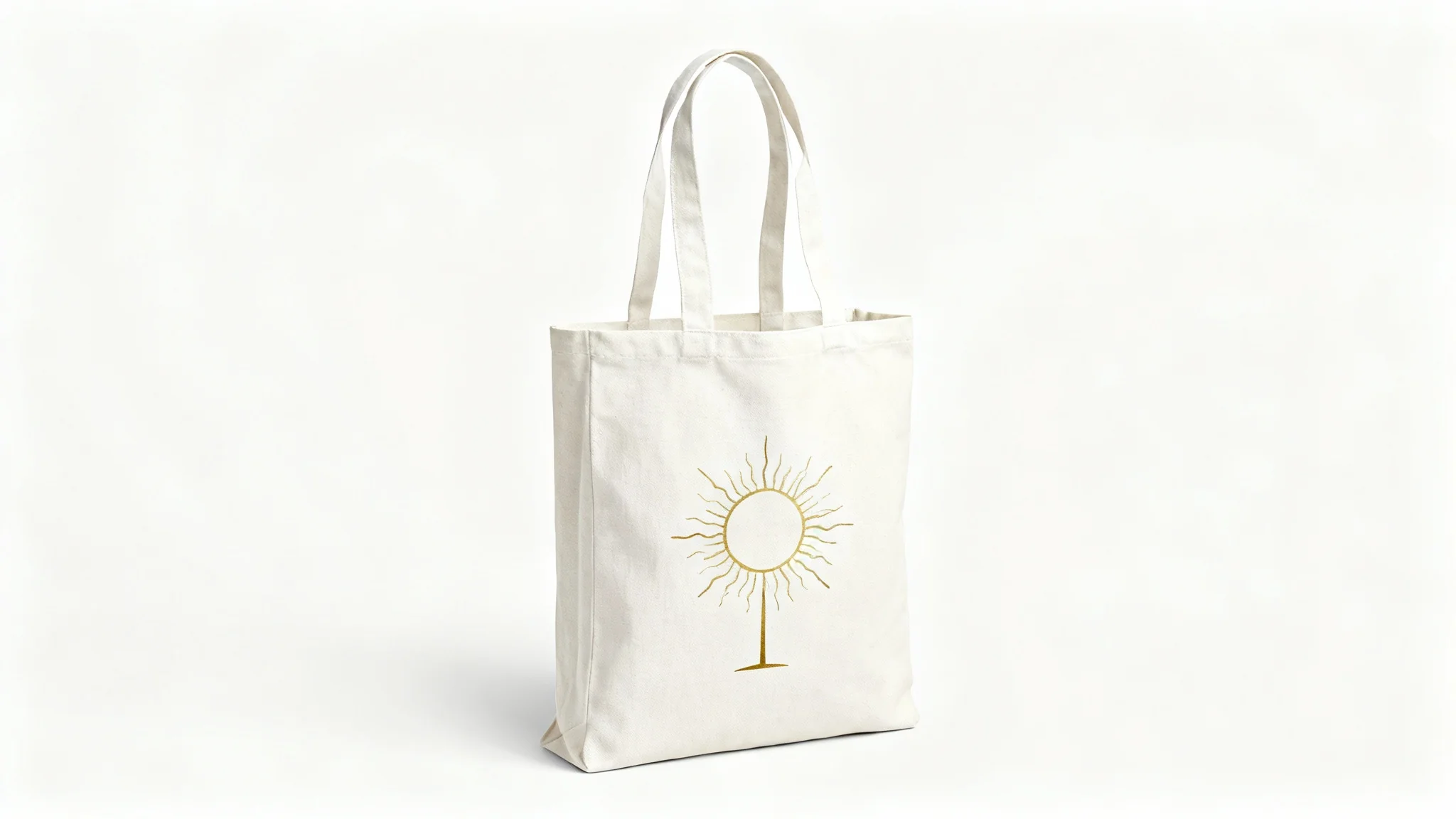 A professional mockup of an off-white canvas tote bag featuring a minimalist golden sun design, shot in a studio setting against a pure white background.