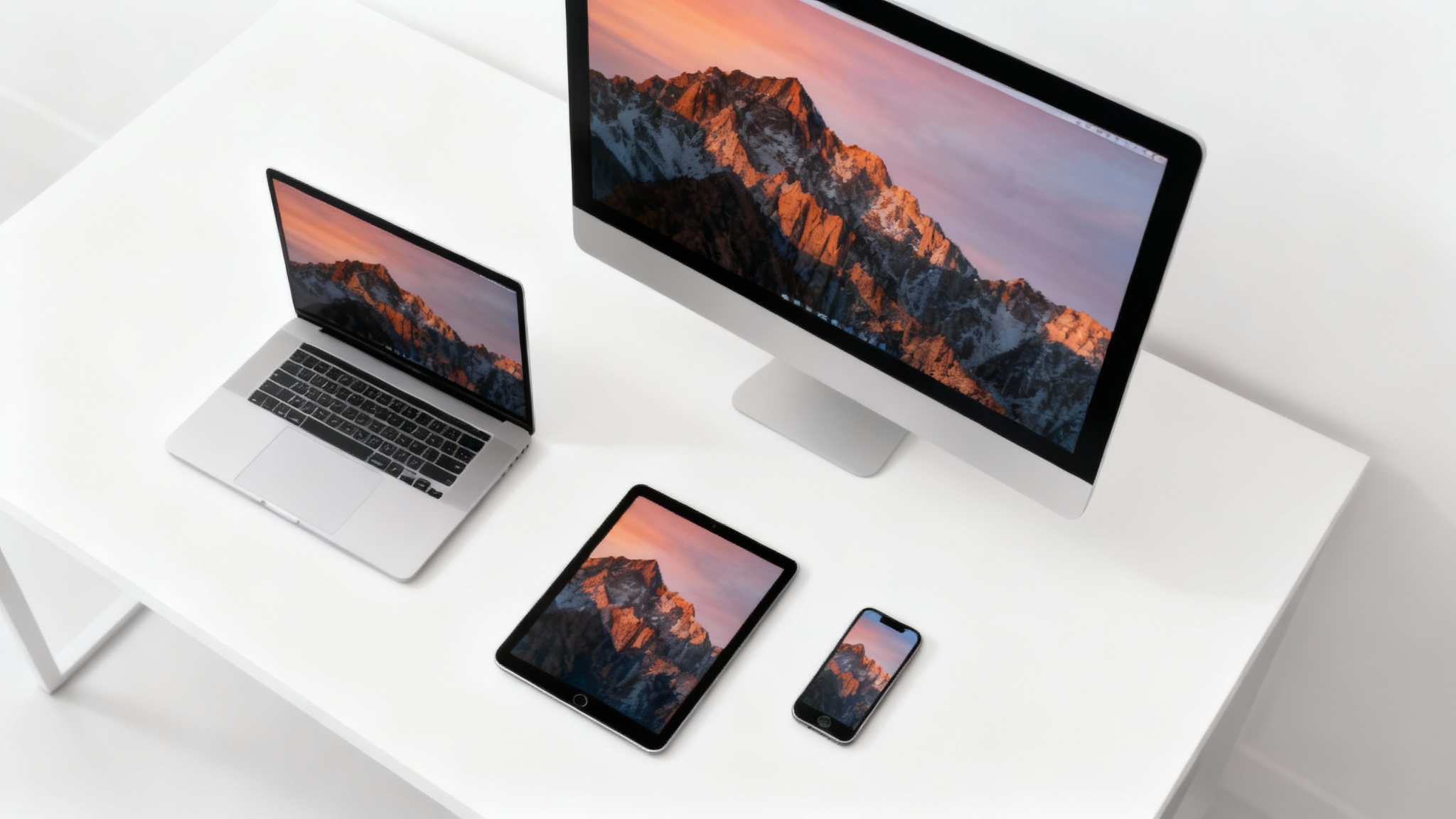 A laptop, desktop monitor, tablet, and phone on a desk, each displaying the same vibrant landscape wallpaper perfectly resized to fit its screen, demonstrating a wallpaper resizing tool.