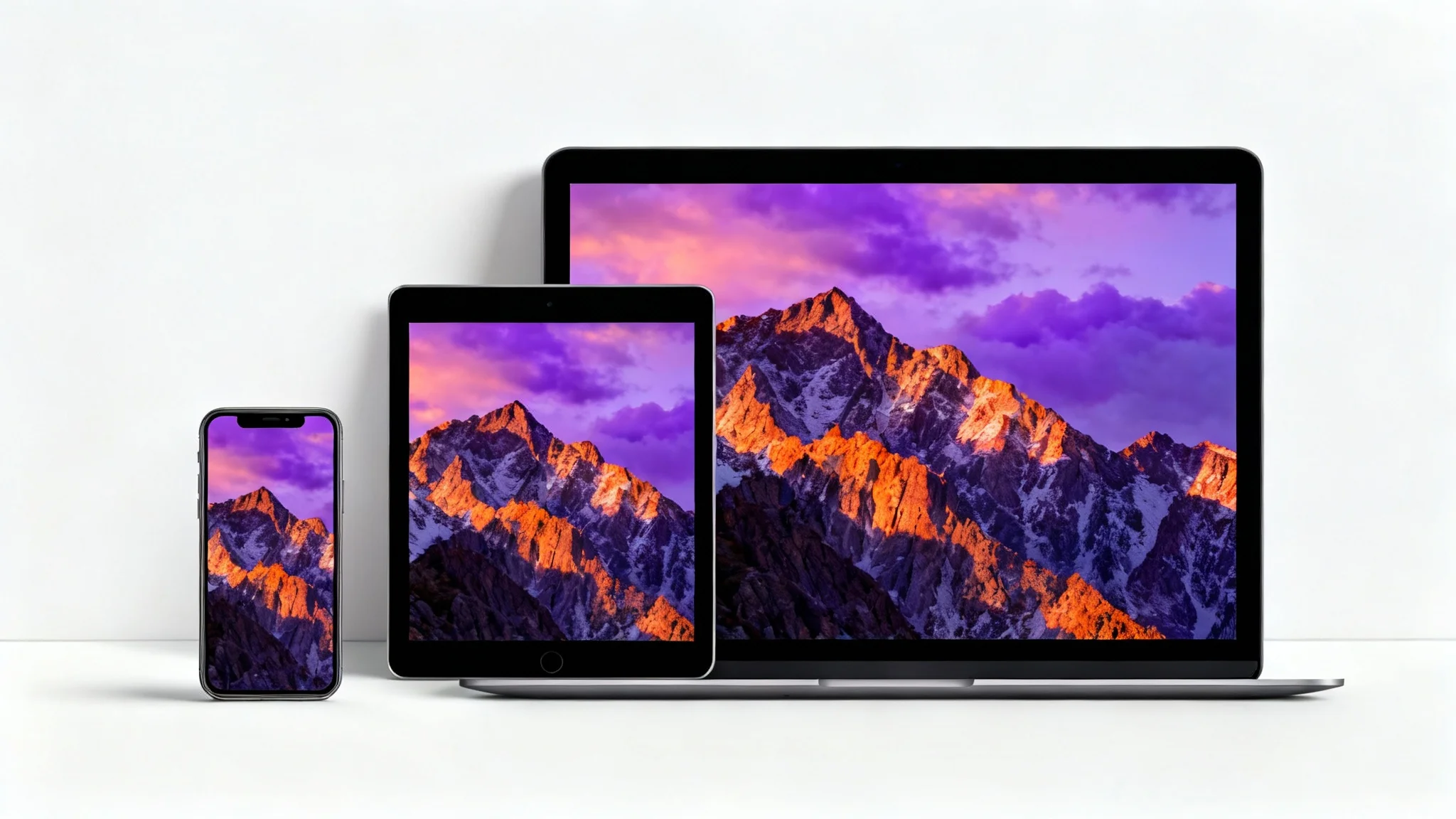 A smartphone, tablet, and laptop side-by-side on a white background, each showing the same mountain sunrise wallpaper perfectly resized for its screen, illustrating a wallpaper resizing tool.