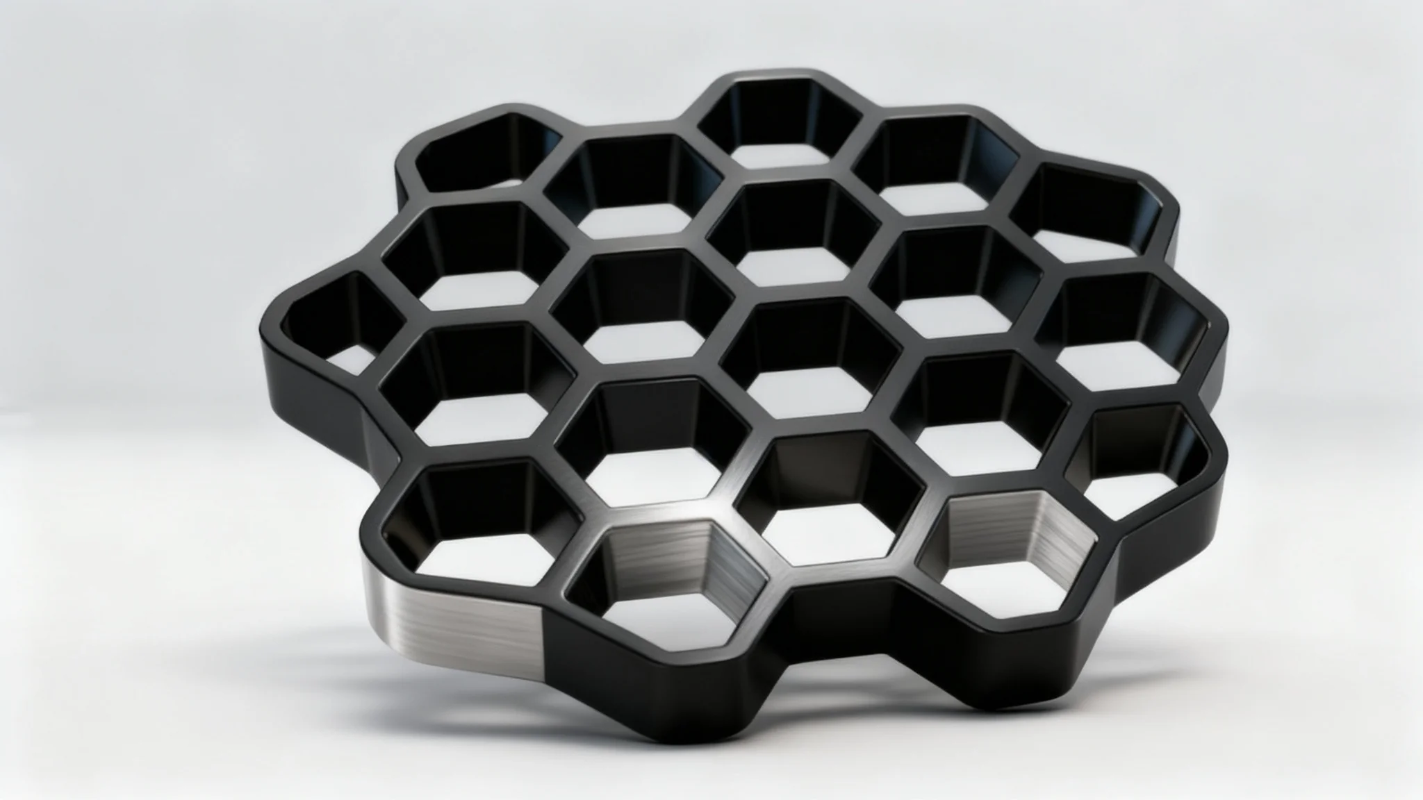 A close-up, photorealistic image of a sleek, matte black industrial component featuring a precise and intricate honeycomb pattern, set against a clean studio background.