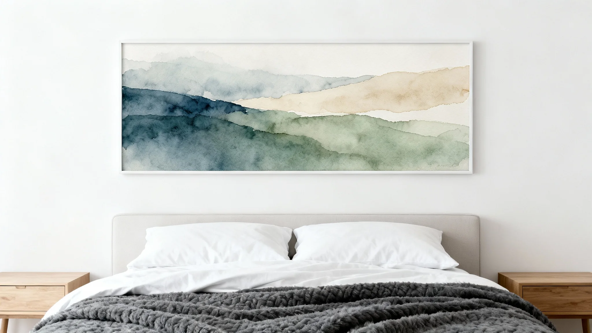 A modern bedroom scene showcasing a large, horizontal abstract landscape art piece hanging above a neatly made bed with white and grey linens, all against a clean white background.