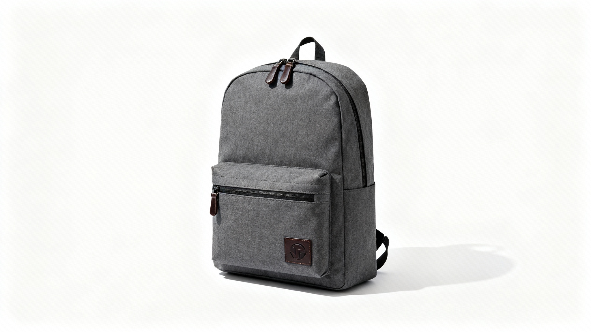 A modern charcoal gray backpack with brown leather details, shown in a professional product photo against a plain white background.