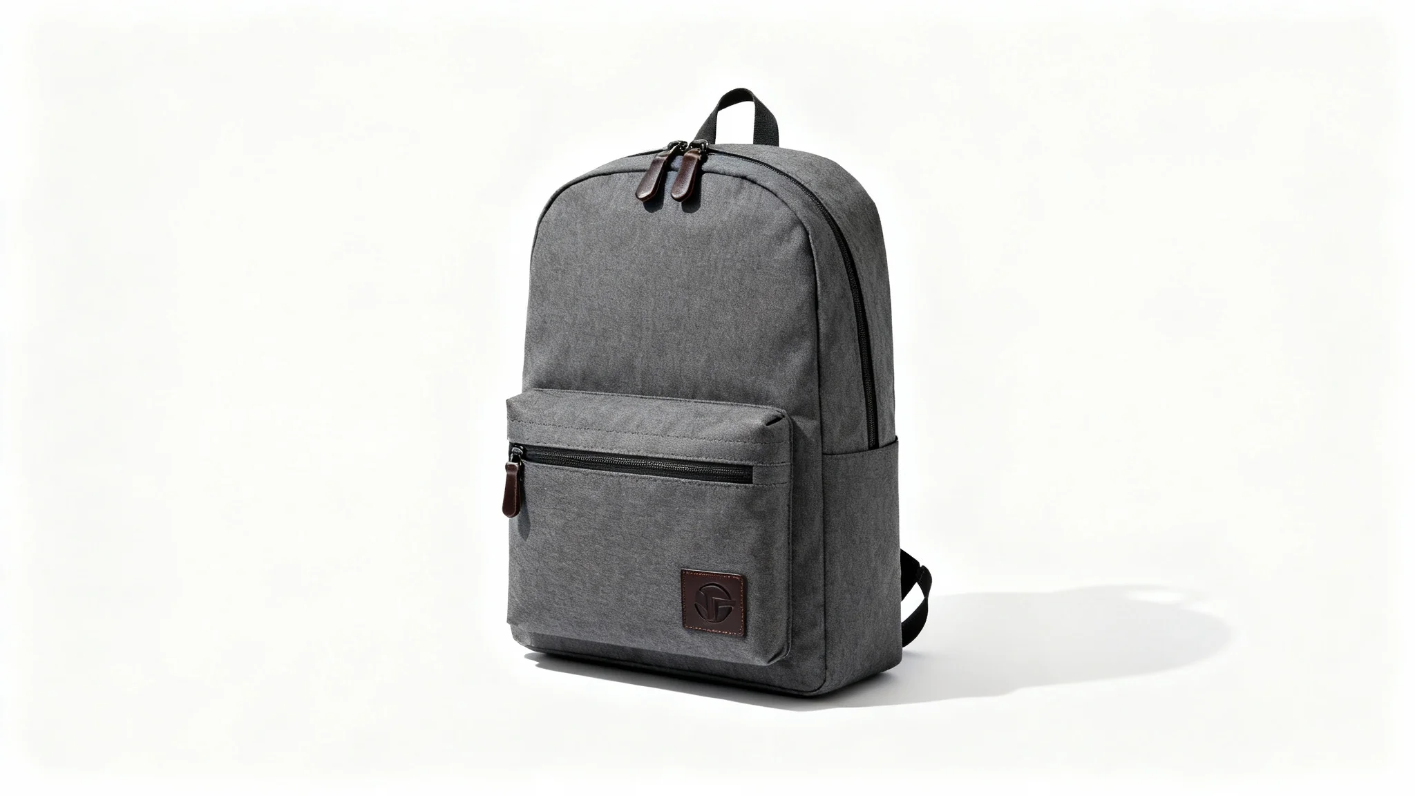 A modern charcoal gray backpack with brown leather details, shown in a professional product photo against a plain white background.