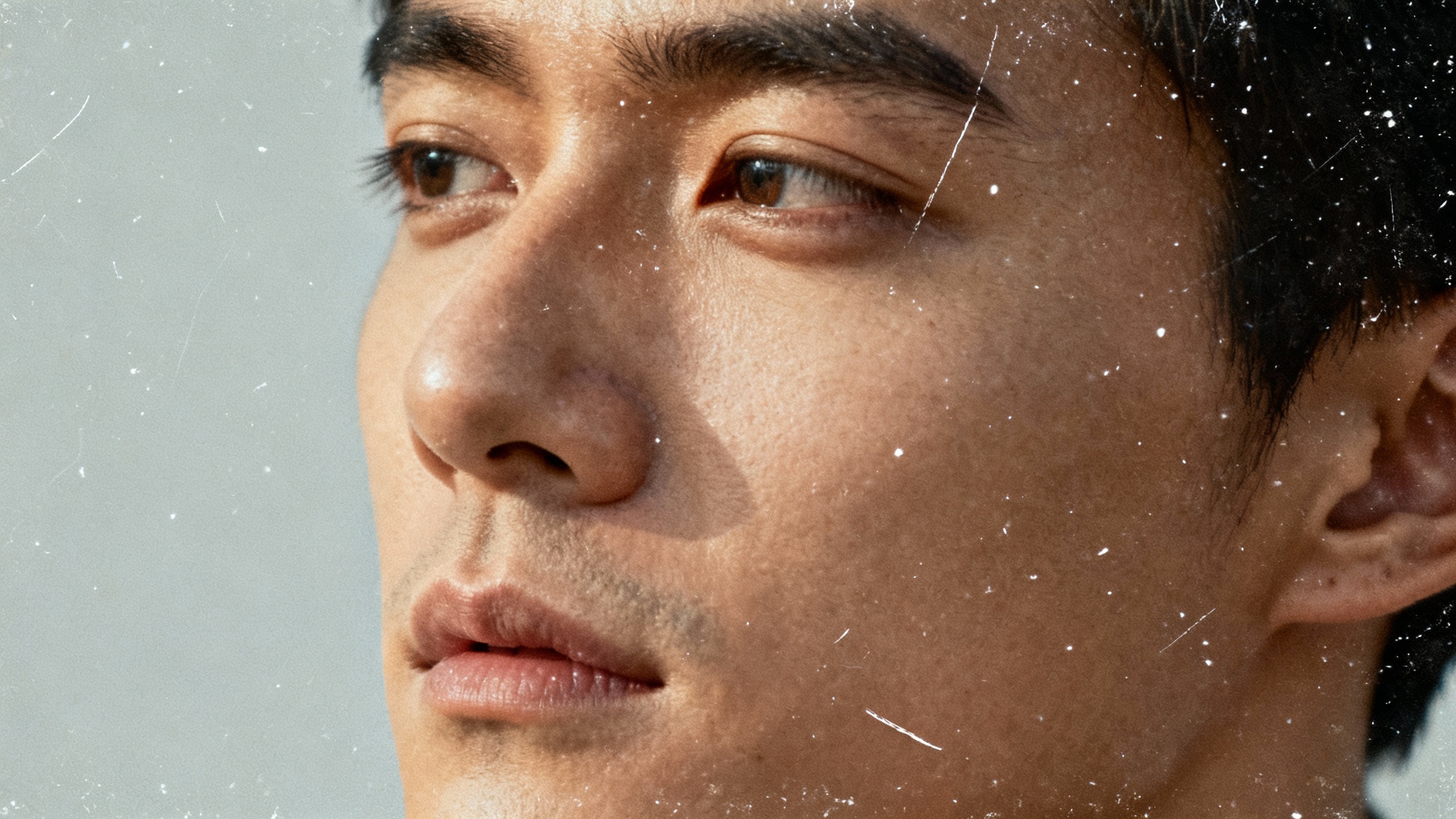 A close-up vintage-style photograph of a person, featuring a realistic dust and scratches overlay that gives the image an aged, nostalgic appearance.