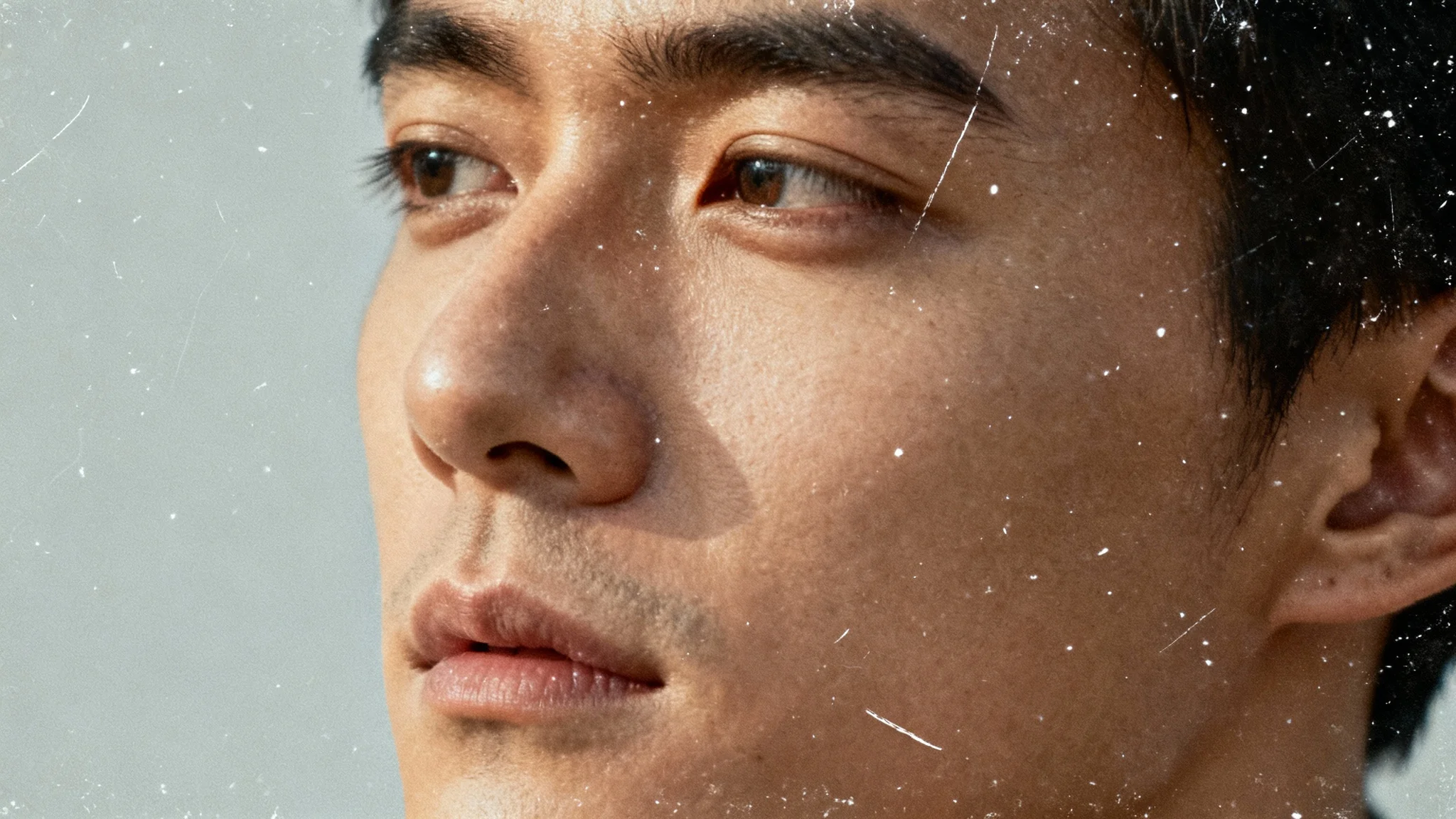 A close-up vintage-style photograph of a person, featuring a realistic dust and scratches overlay that gives the image an aged, nostalgic appearance.