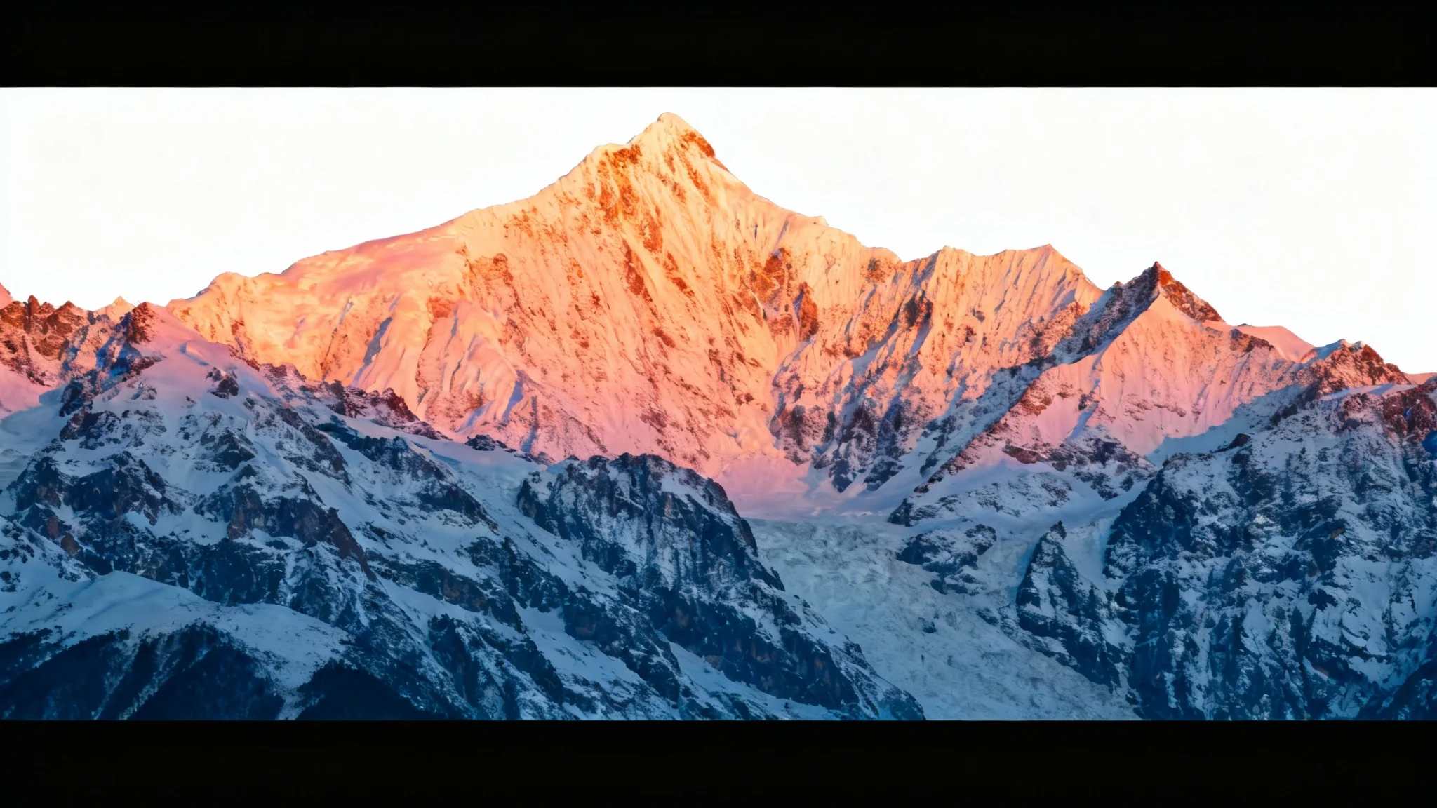 A photo of a mountain range at sunset that has been modified with black bars at the top and bottom to create a cinematic, widescreen appearance, presented against a white background.