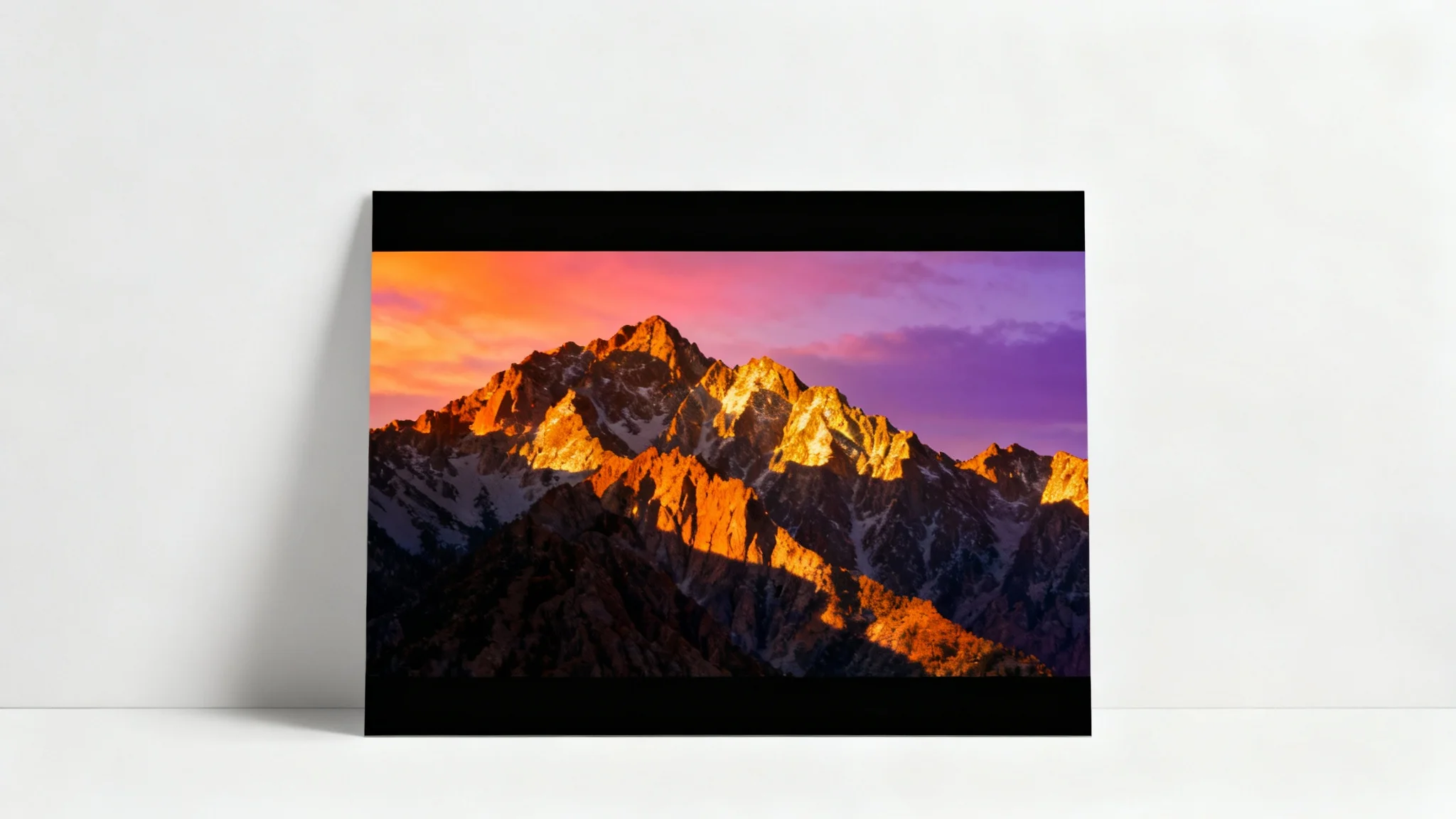 A mockup demonstrating the 'add black bars' effect, showing a cinematic landscape photo of a mountain sunset with black bars at the top and bottom, set against a plain white background.