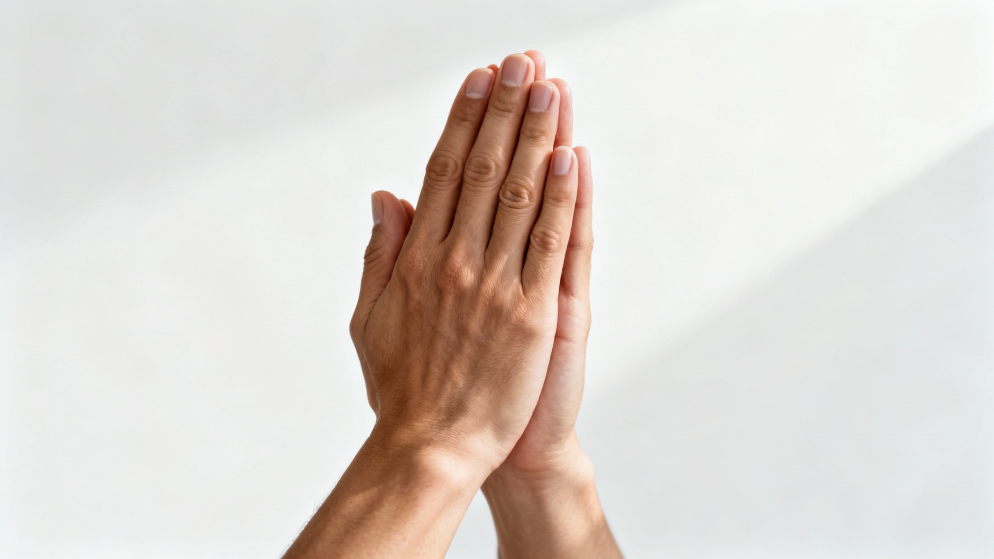 A photorealistic image of two hands clasped together in prayer, shown in close-up against a clean white background, creating a serene and spiritual feeling.