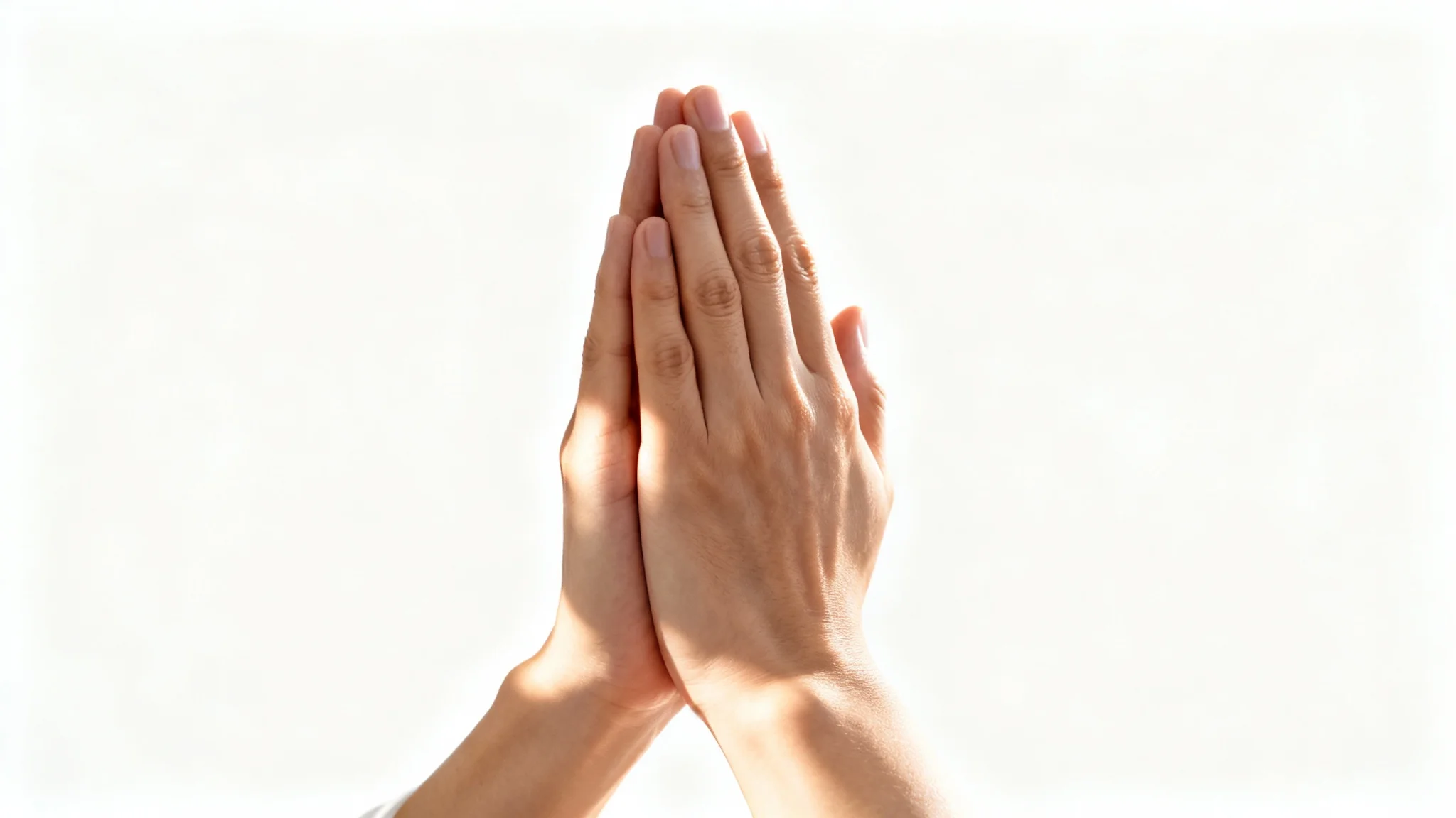 A close-up, photorealistic image of two hands clasped together in prayer, set against a sterile white background with soft, warm lighting.
