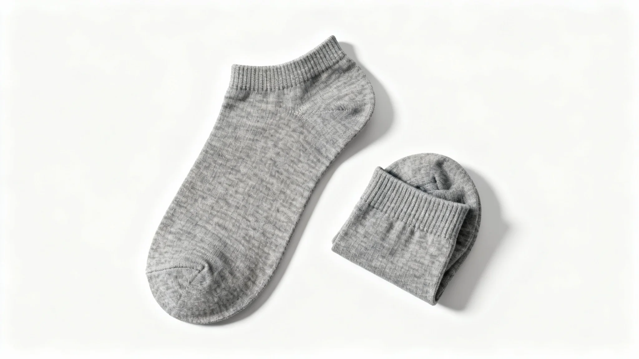A photorealistic mockup of a pair of heather gray ankle socks, arranged neatly in a flat lay on a clean white background.