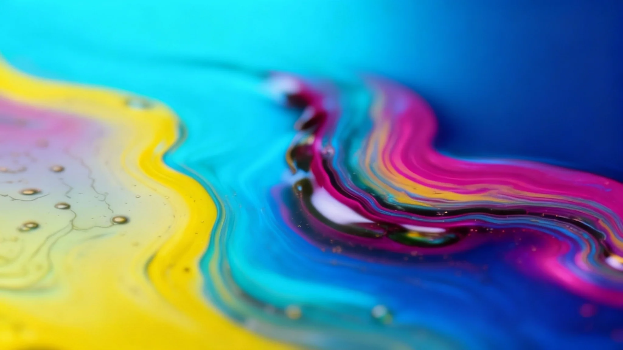 An abstract digital artwork demonstrating a hue shift effect. The image shows swirling, translucent shapes that shift from yellow to magenta, set against a gradient background that moves from cyan to deep indigo.