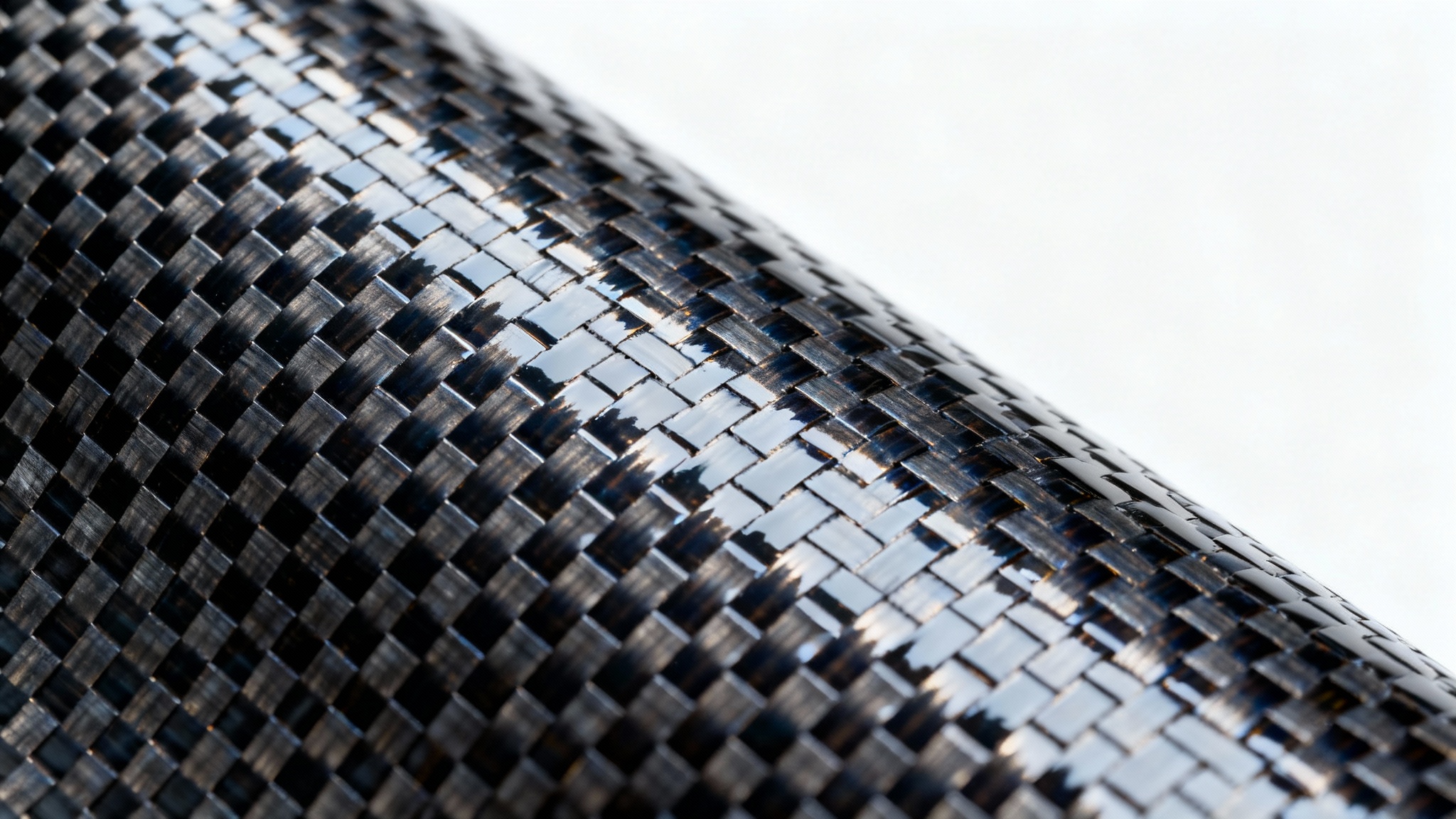 A detailed, close-up photograph of a glossy carbon fiber texture with a distinct twill weave pattern, set against a plain white background.
