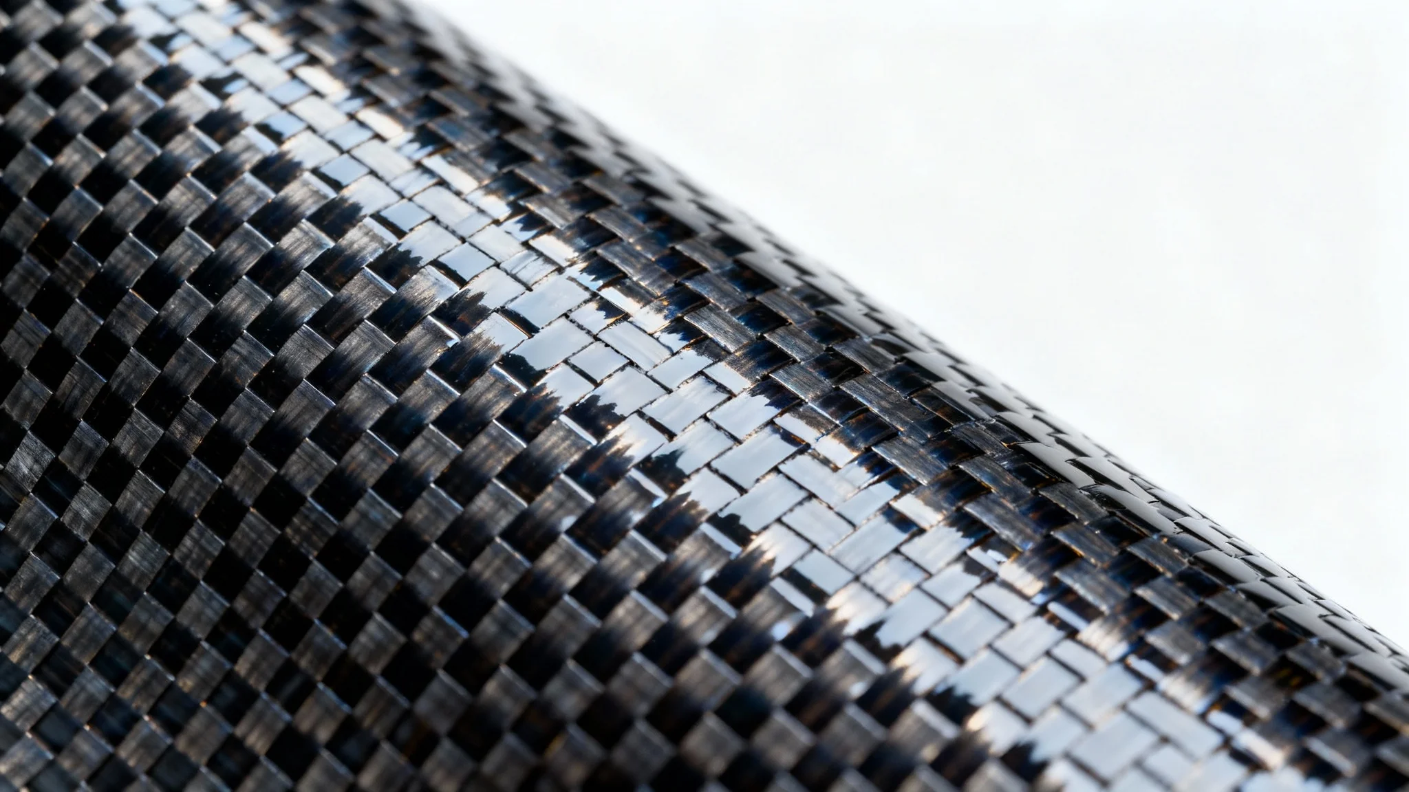 A detailed, close-up photograph of a glossy carbon fiber texture with a distinct twill weave pattern, set against a plain white background.