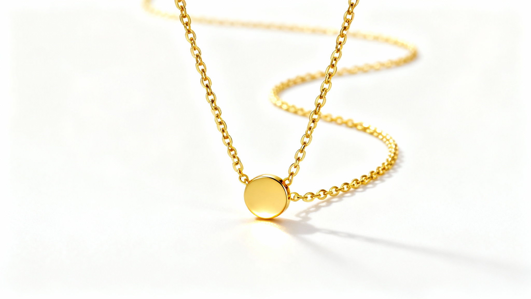 A beautifully crafted 18k gold necklace with a simple circular pendant, displayed elegantly against a clean white background in a professional product photograph.