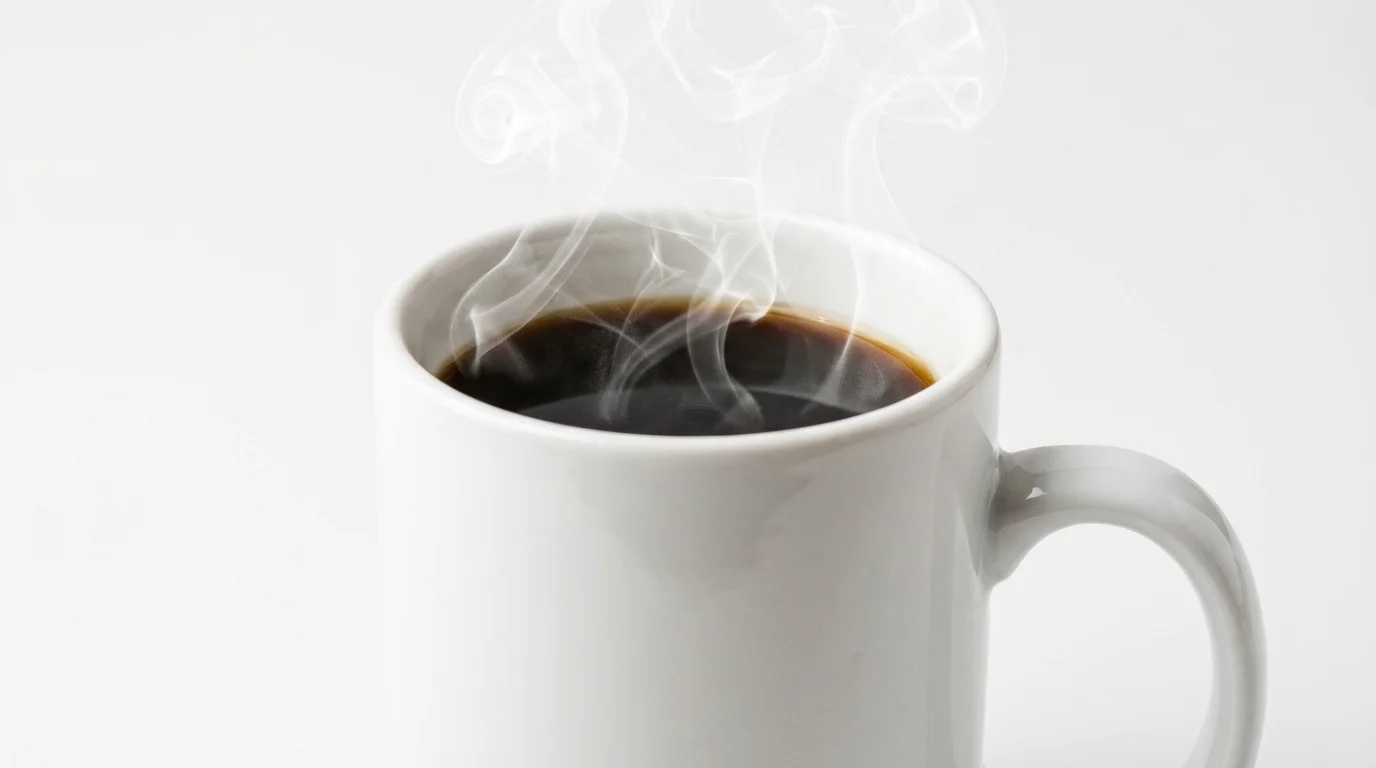 A close-up of a white ceramic mug filled with hot black coffee, with elegant swirls of steam rising from it, set against a plain white background.