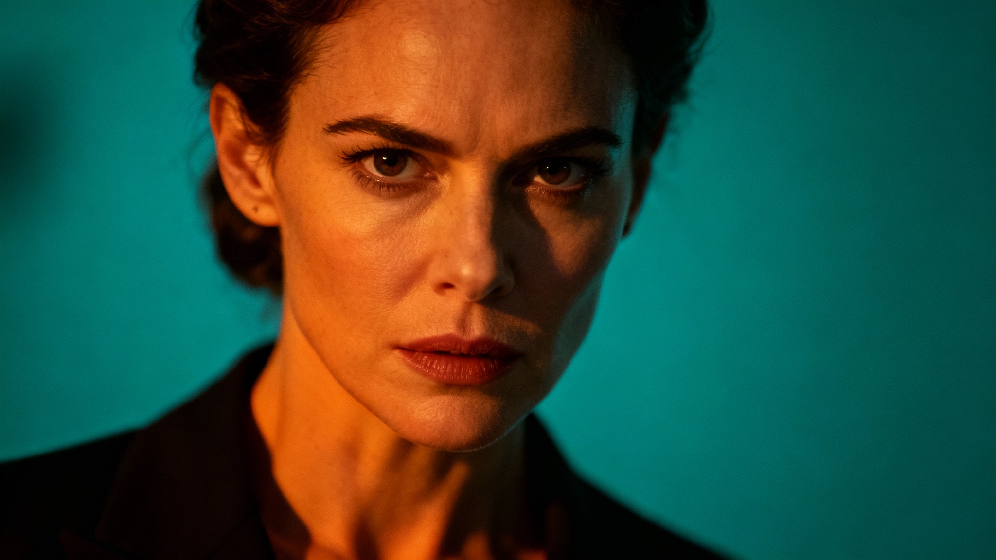 A cinematic photo of a woman's face, demonstrating a Hollywood-style color grade with strong teal shadows and warm orange highlights on her skin.