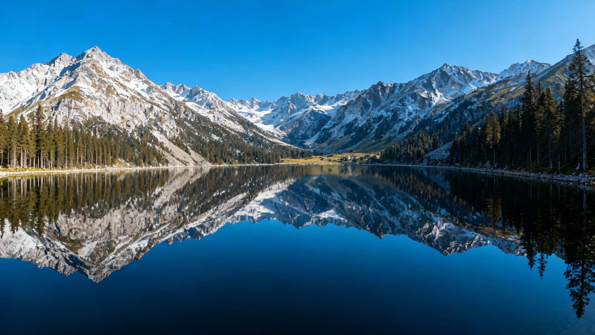 A beautiful, high-resolution landscape photograph of mountains and a lake, shown after being corrected for lens distortion. The horizon is perfectly straight, and the trees stand upright without any visual warping.