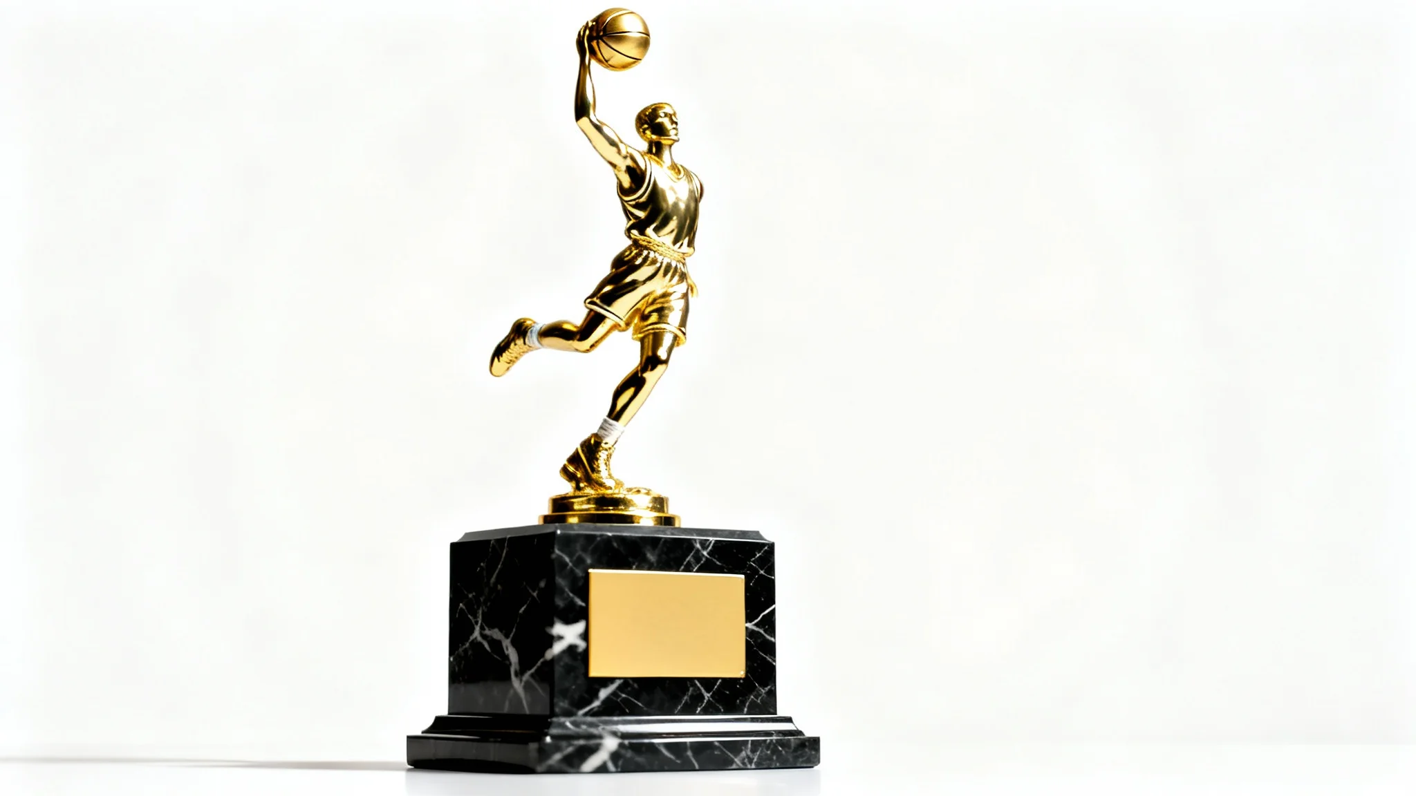 A close-up studio shot of a gleaming gold basketball trophy, featuring a player in a dunking pose on a polished black marble base, set against a solid white background.