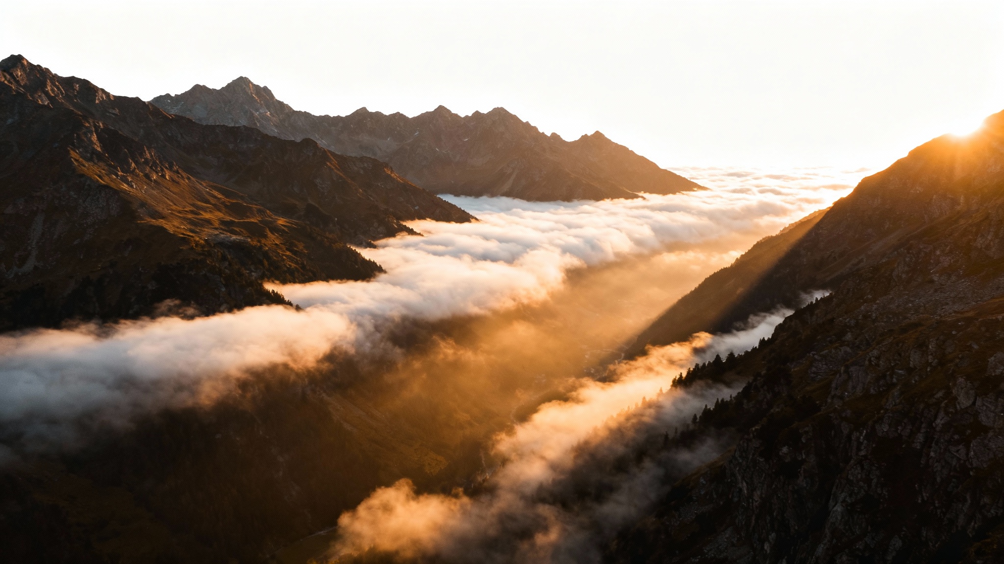 A photorealistic image of a mountain range at sunrise, with thick fog filling the valleys, demonstrating the 'add fog' effect.