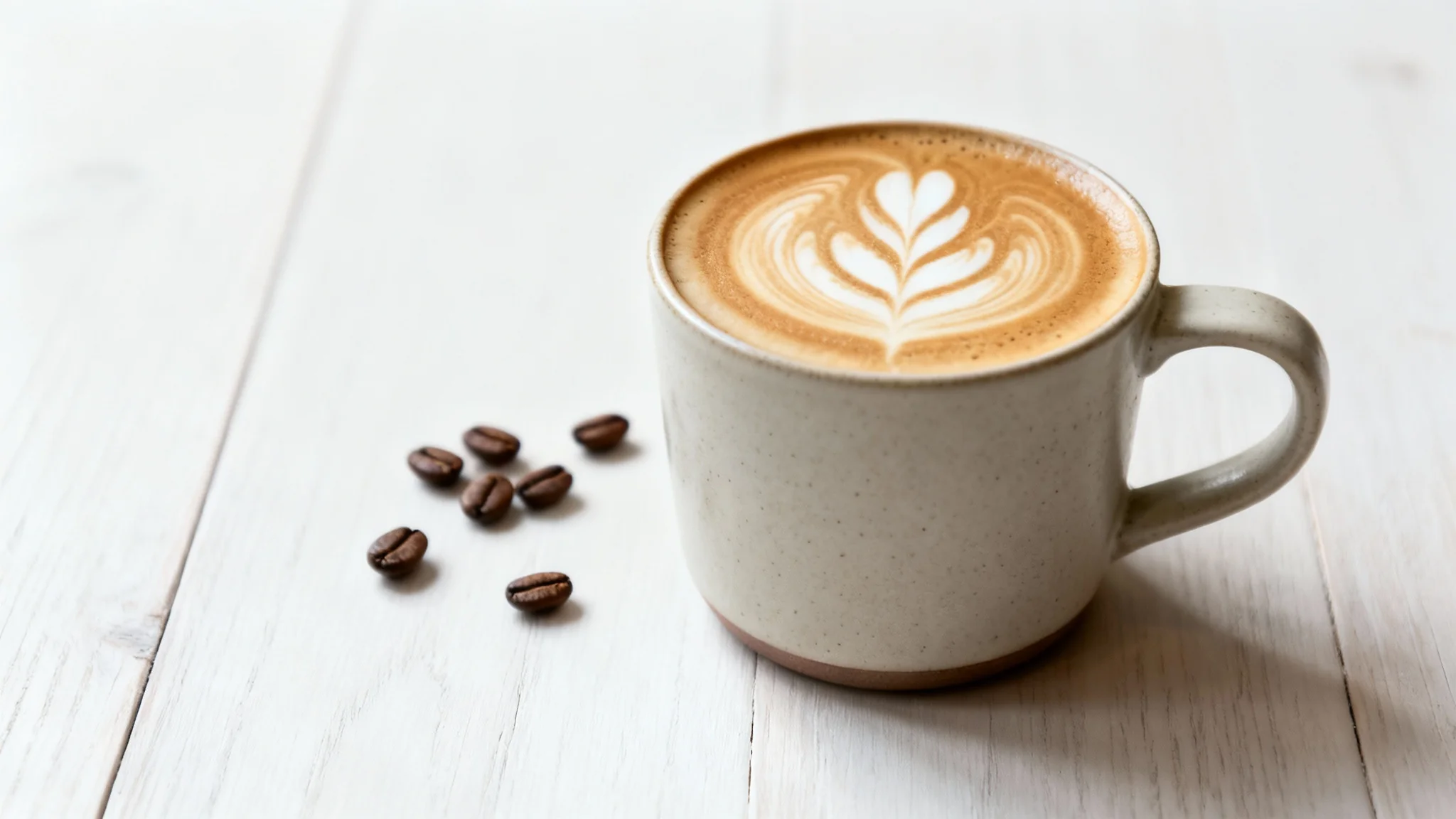 A professional, vertical photograph in a 4:5 aspect ratio showing a close-up of a latte with rosetta art in a ceramic mug, demonstrating the output of an aspect ratio converter.