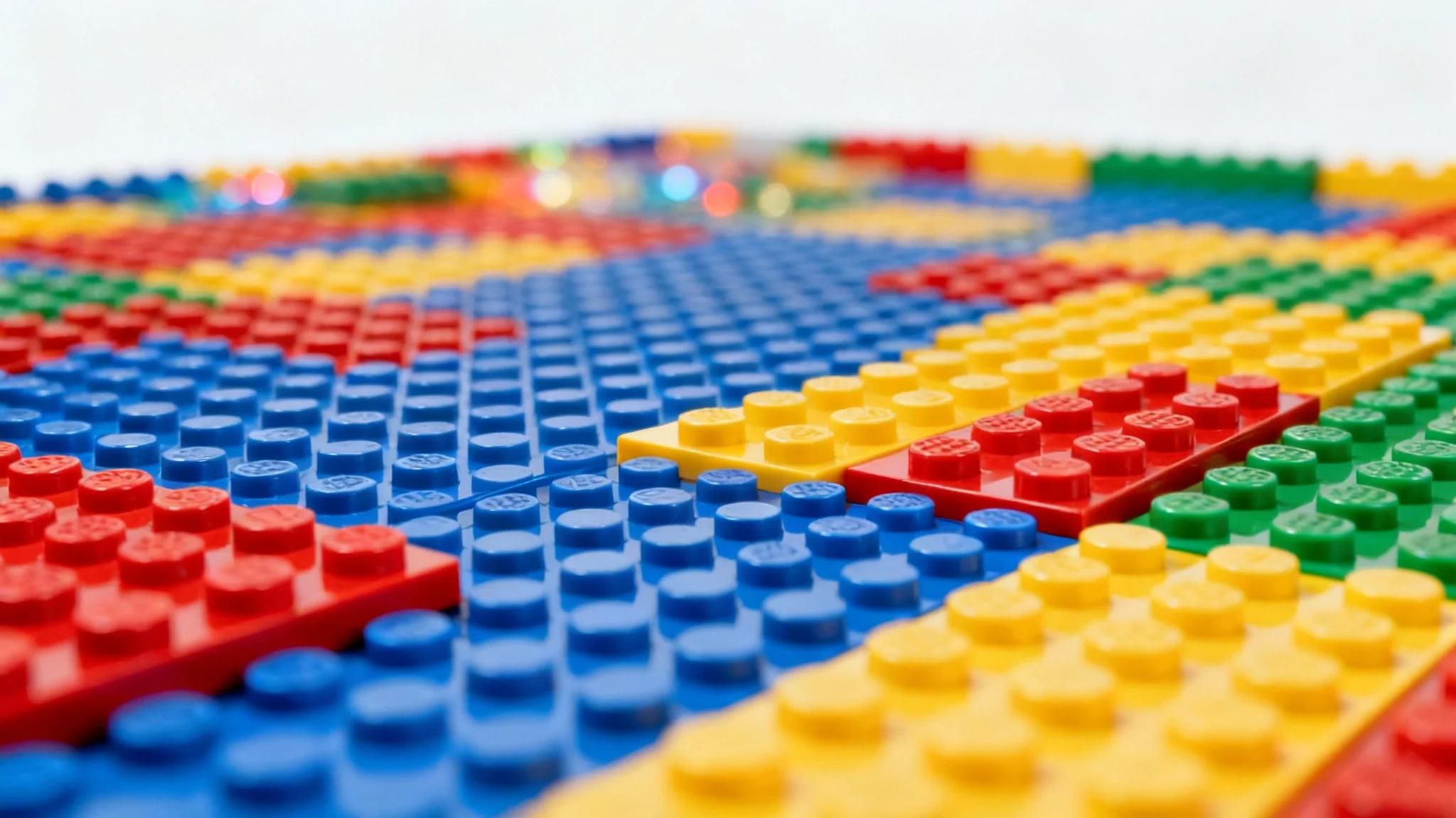 A colorful background made of interlocking toy bricks, shown from a low angle with a shallow depth of field that highlights the texture.