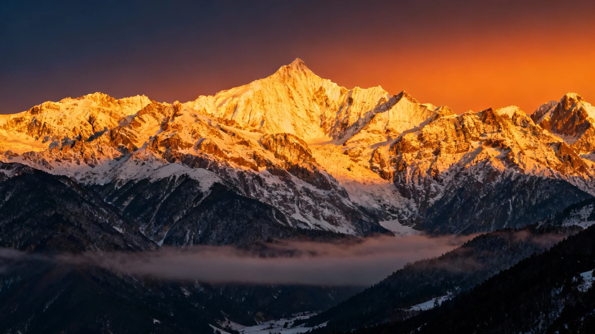 A stunning, widescreen photo of a mountain range at sunrise, framed with cinematic black letterbox bars at the top and bottom.