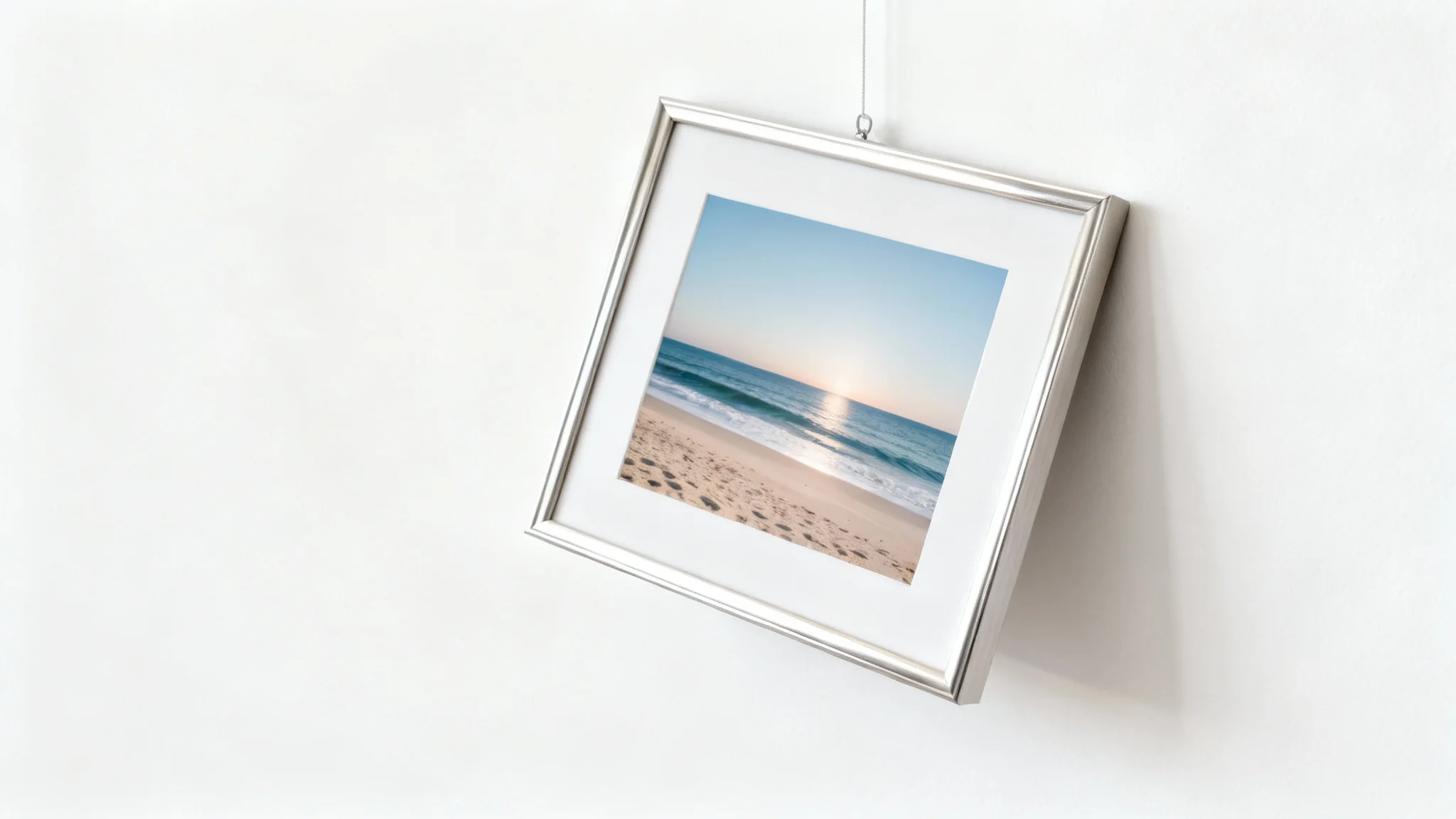 A photorealistic mockup of a picture frame with a landscape photo hanging crookedly on a white wall, representing a tilted photo that needs straightening.