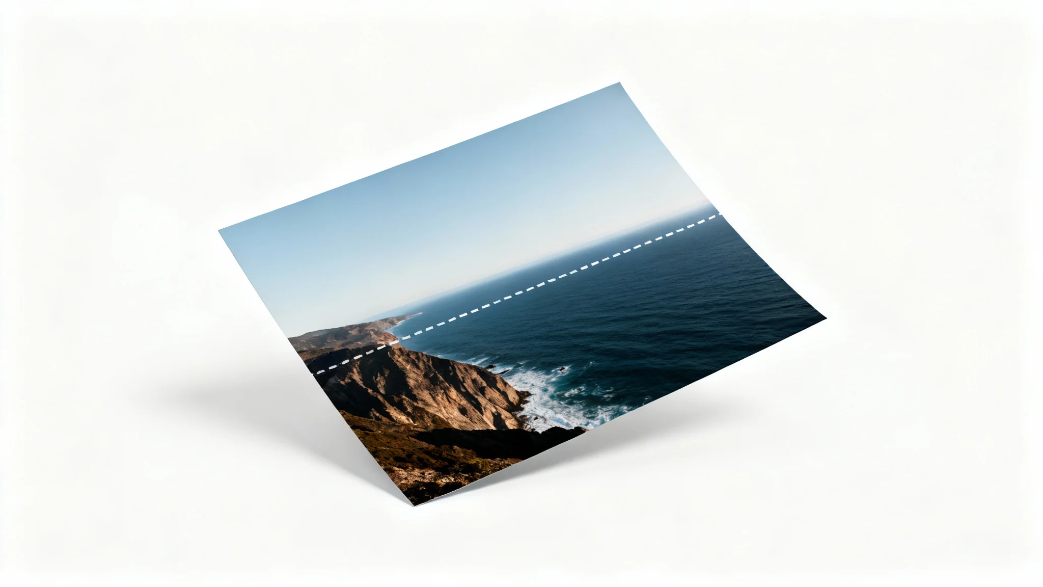 A tilted photograph of a coastal scene with a horizontal dashed line superimposed, demonstrating the process of straightening the photo.